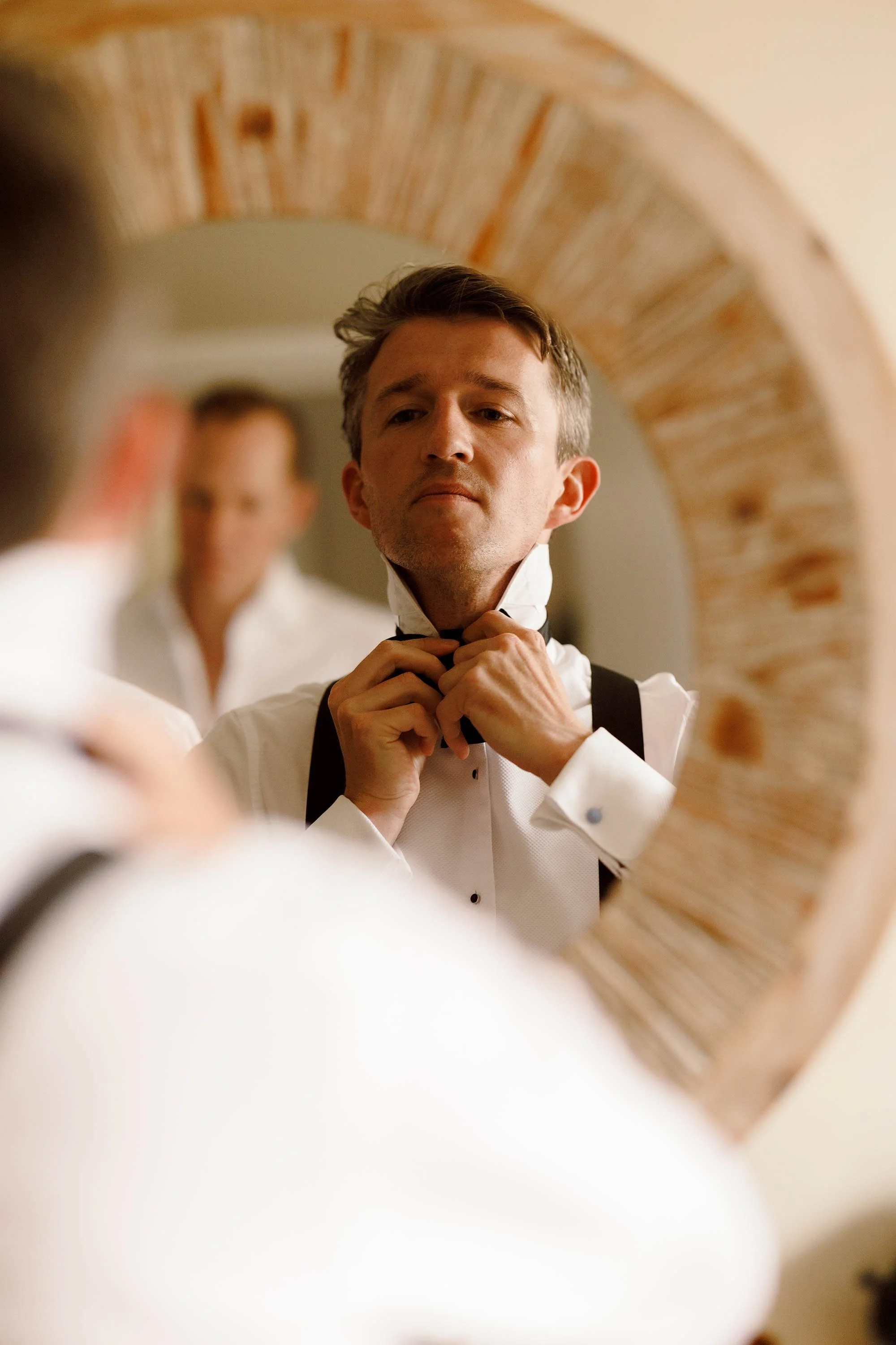 groom does bowtie for nevill holt estate wedding