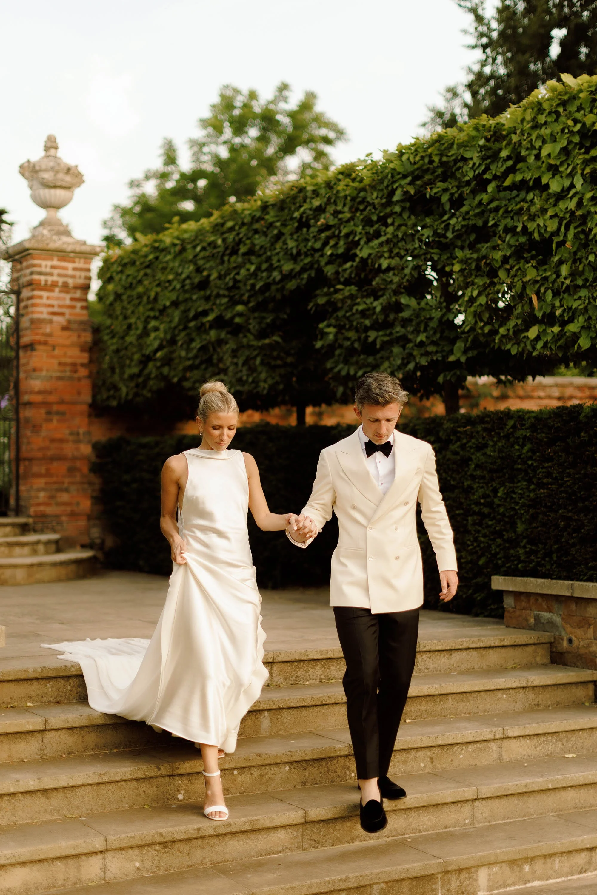 bride and groom explore venue grounds at nevill holt estate