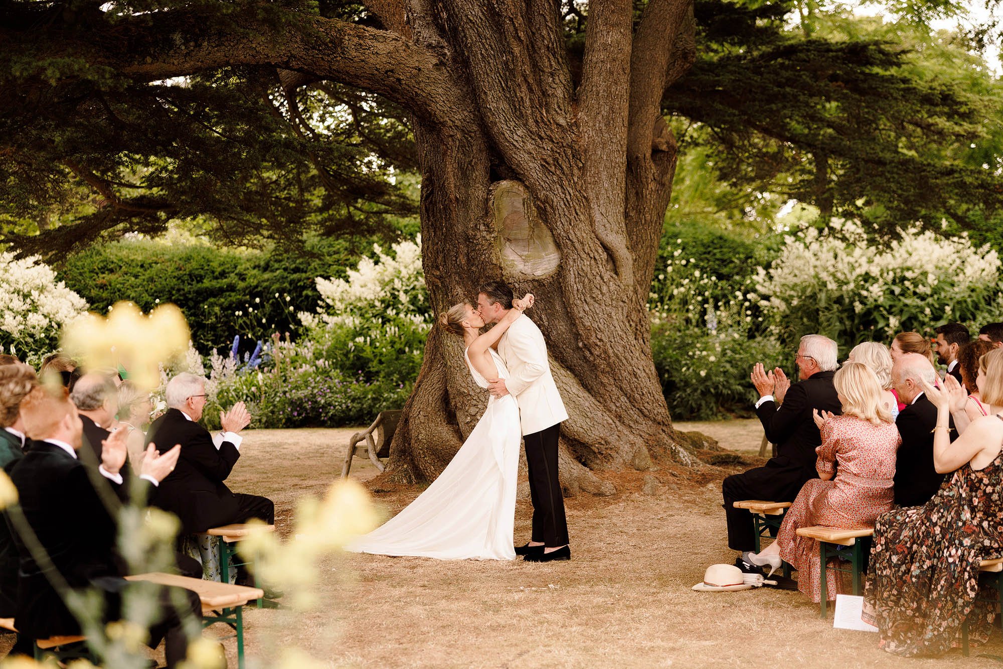 bride and groom first kiss in outdoor ceremony