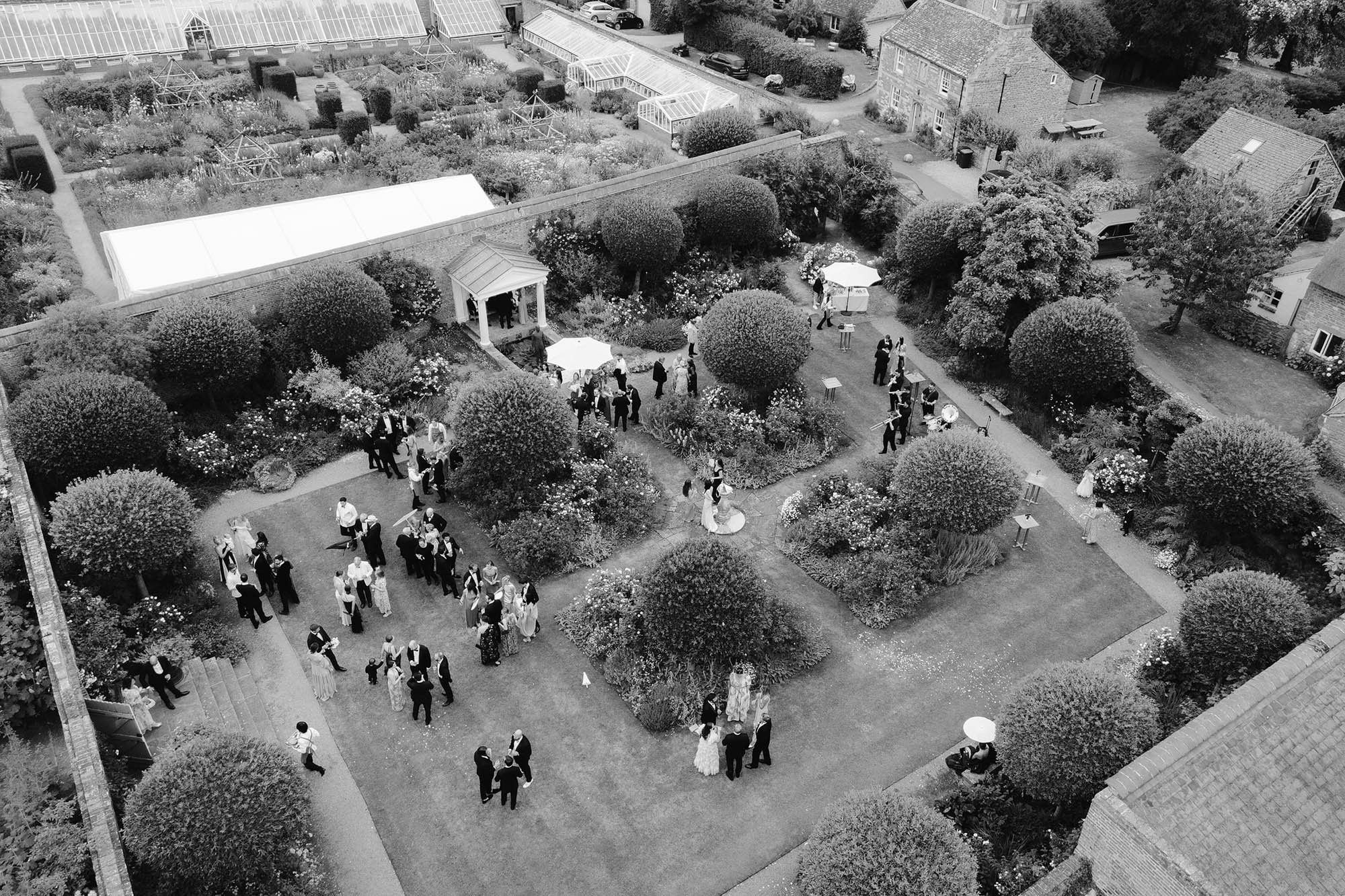 aerial photo of guests mingling in walled garden