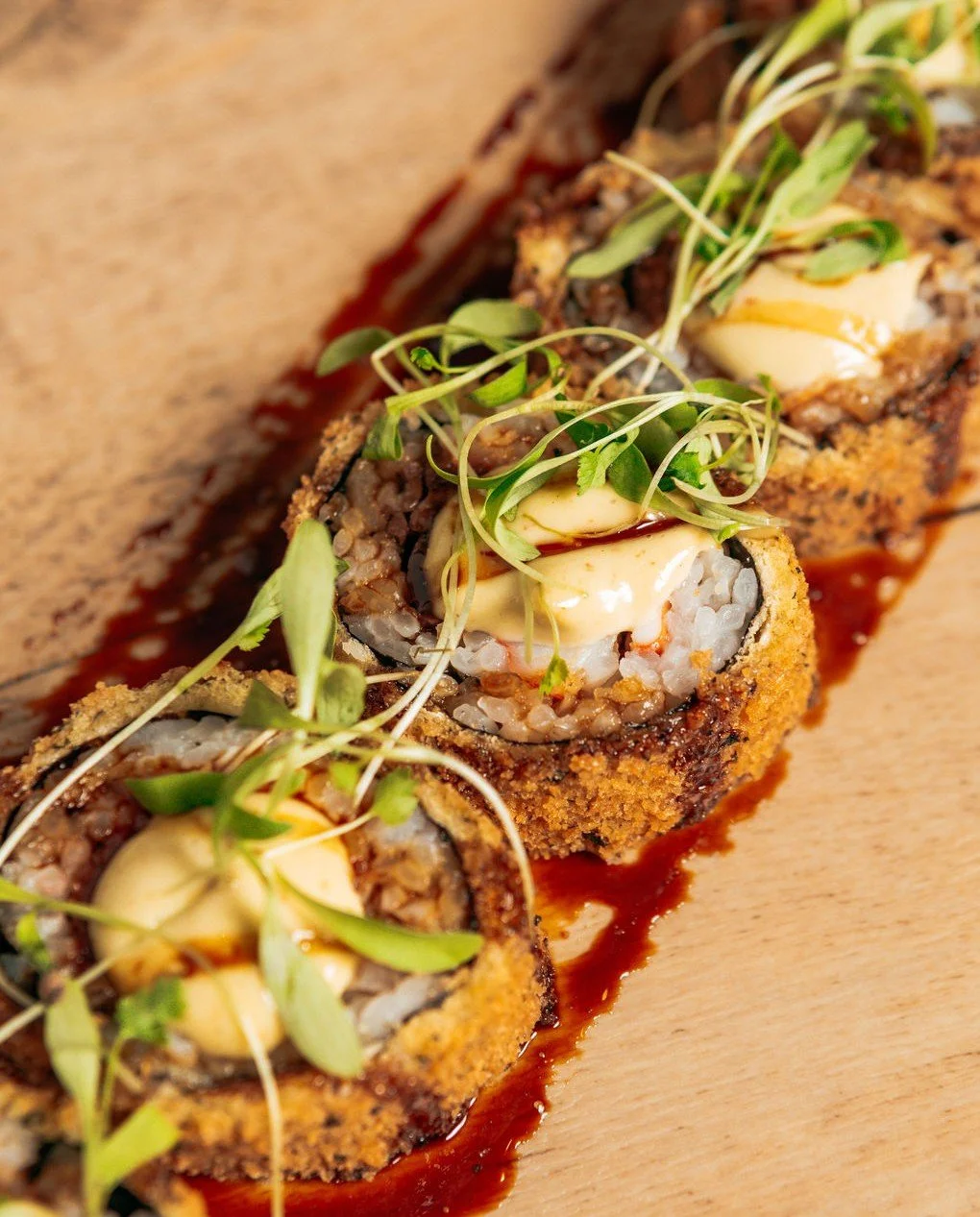 Steak and lobster wrapped in a crisp tempura roll with cream cheese and scallions, finished with sweet soy and chili wasabi aioli. Rich, balanced, and exactly the point.