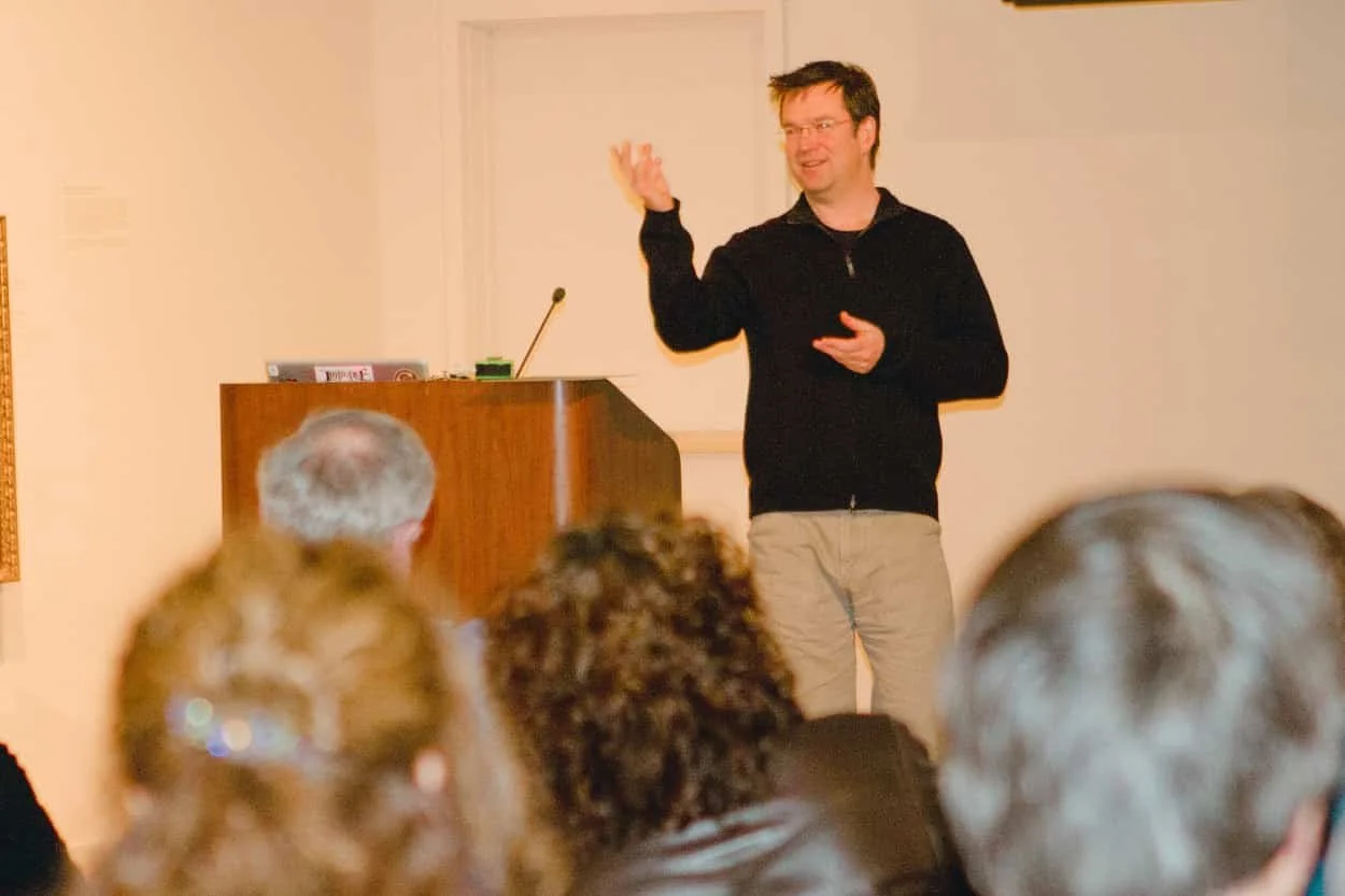 Scott Indermaur speaking to an audience during a public presentation for the REVEALED museum exhibition.