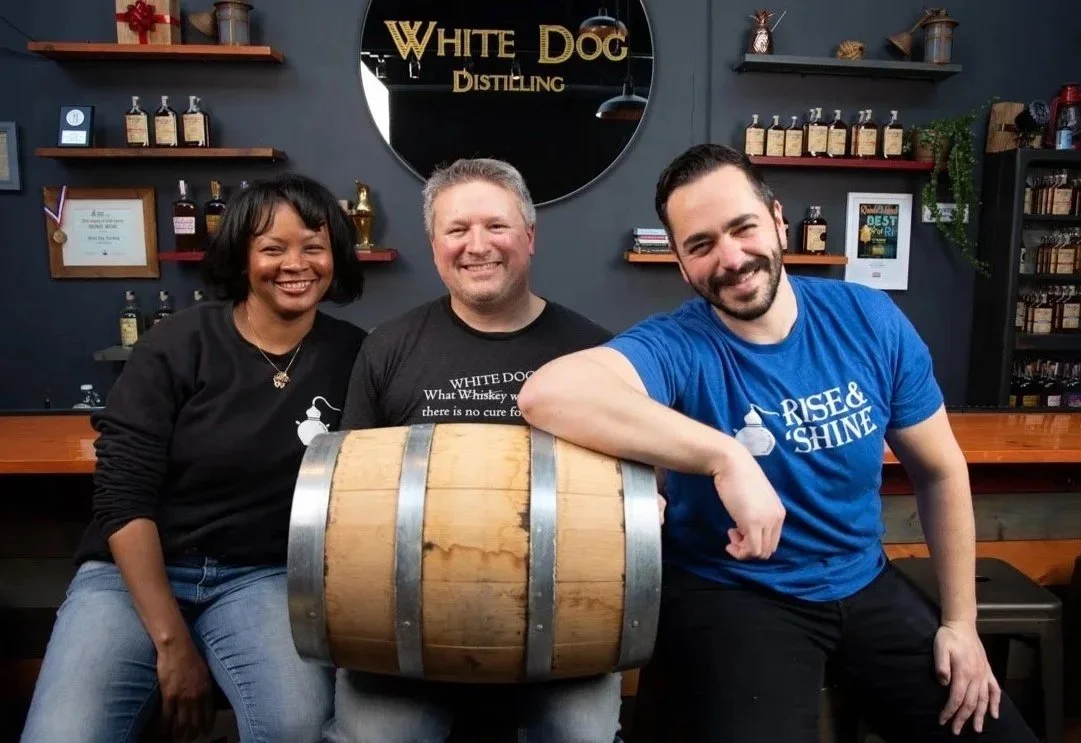 Team portrait at White Dog Distilling in Rhode Island showing updated business photography in a distillery setting