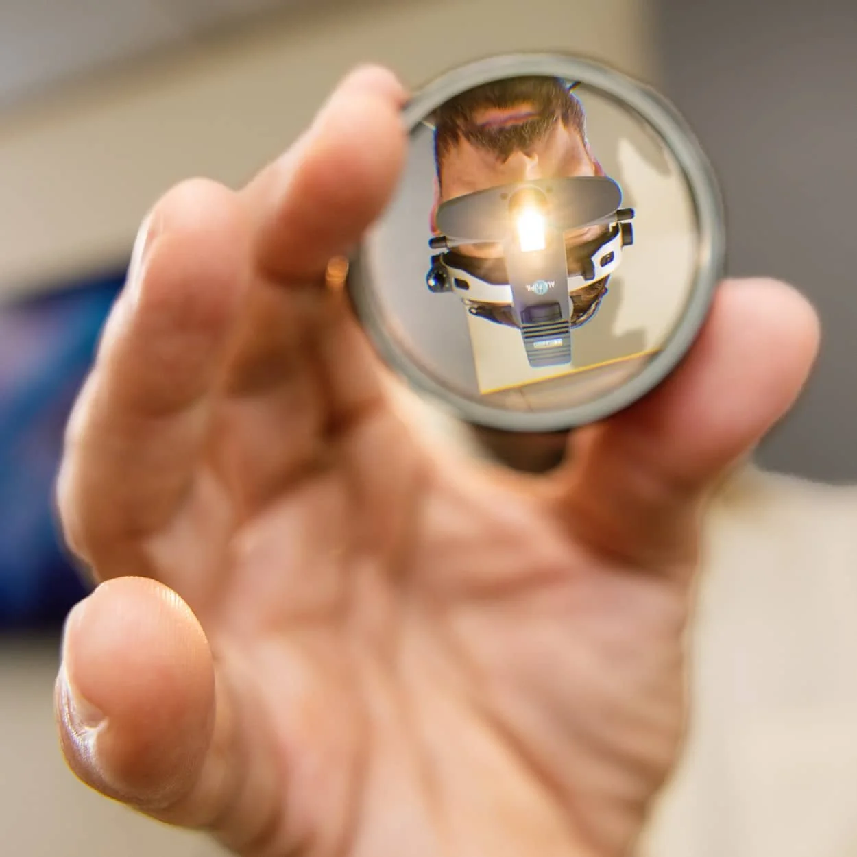 Dr. John Magalheas reflected in an examination lens while performing an eye exam.