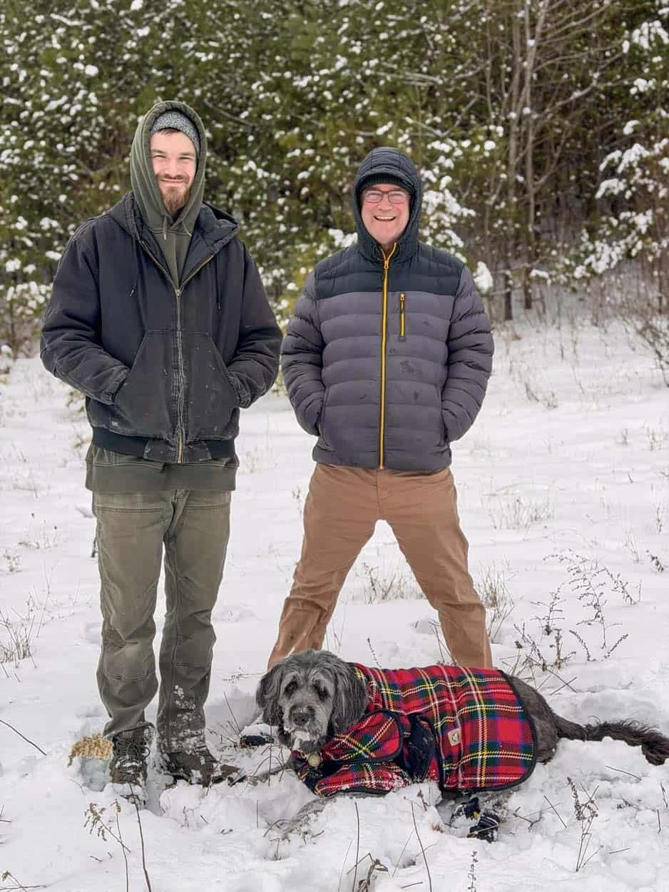 Scott Indermaur and his son Trueb standing in snow after driving an Airstream up a steep mountain road in New Hampshire.