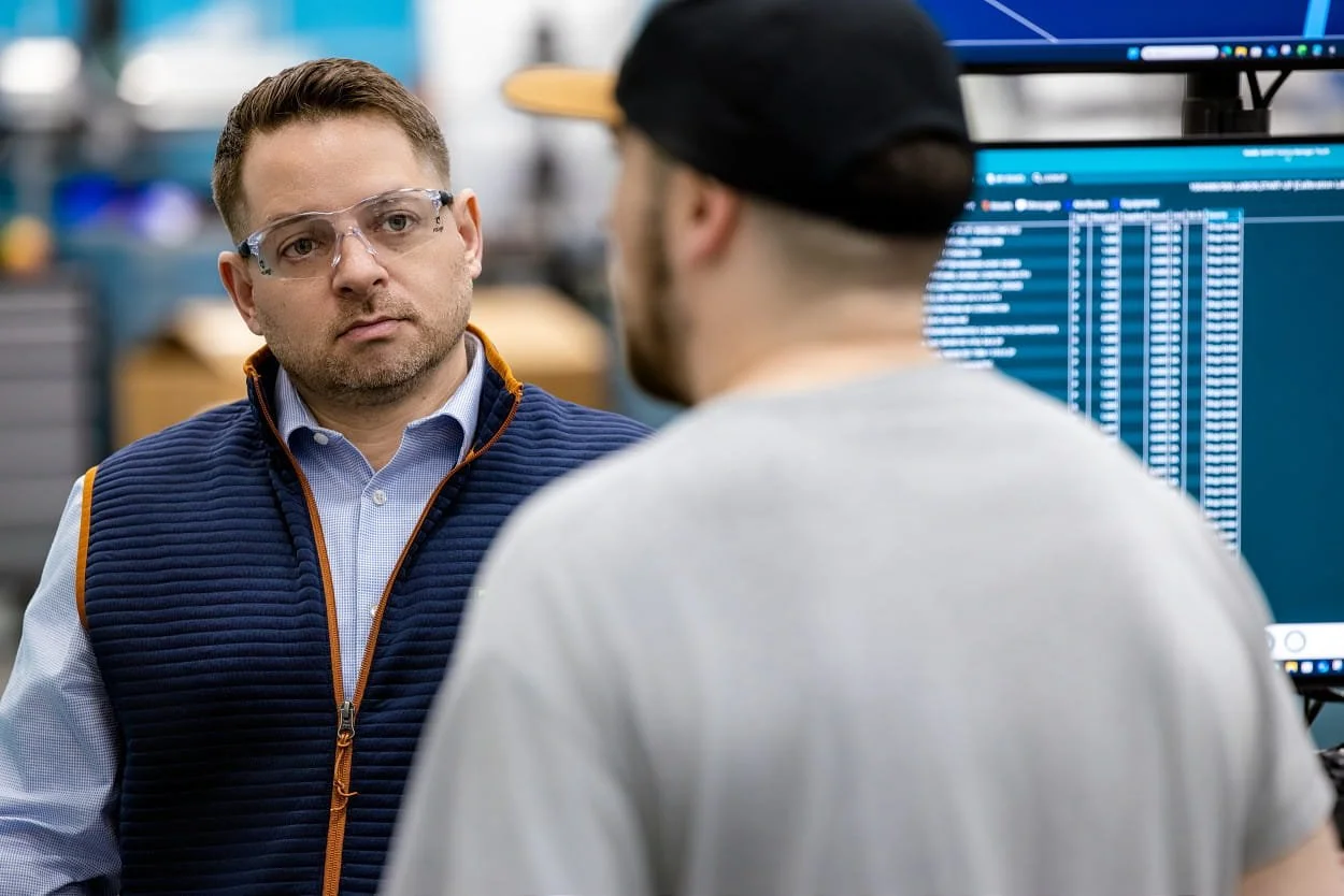 Polaris associate speaking with a Hexagon associate during a manufacturing facility visit in North Kingstown, Rhode Island.