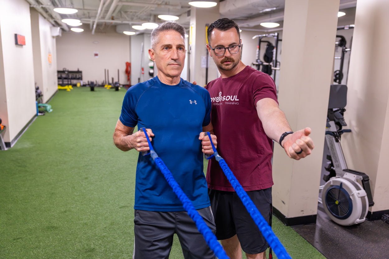 Body Soul Training personal trainer coaching a client through a resistance-band exercise in the Providence, Rhode Island studio.