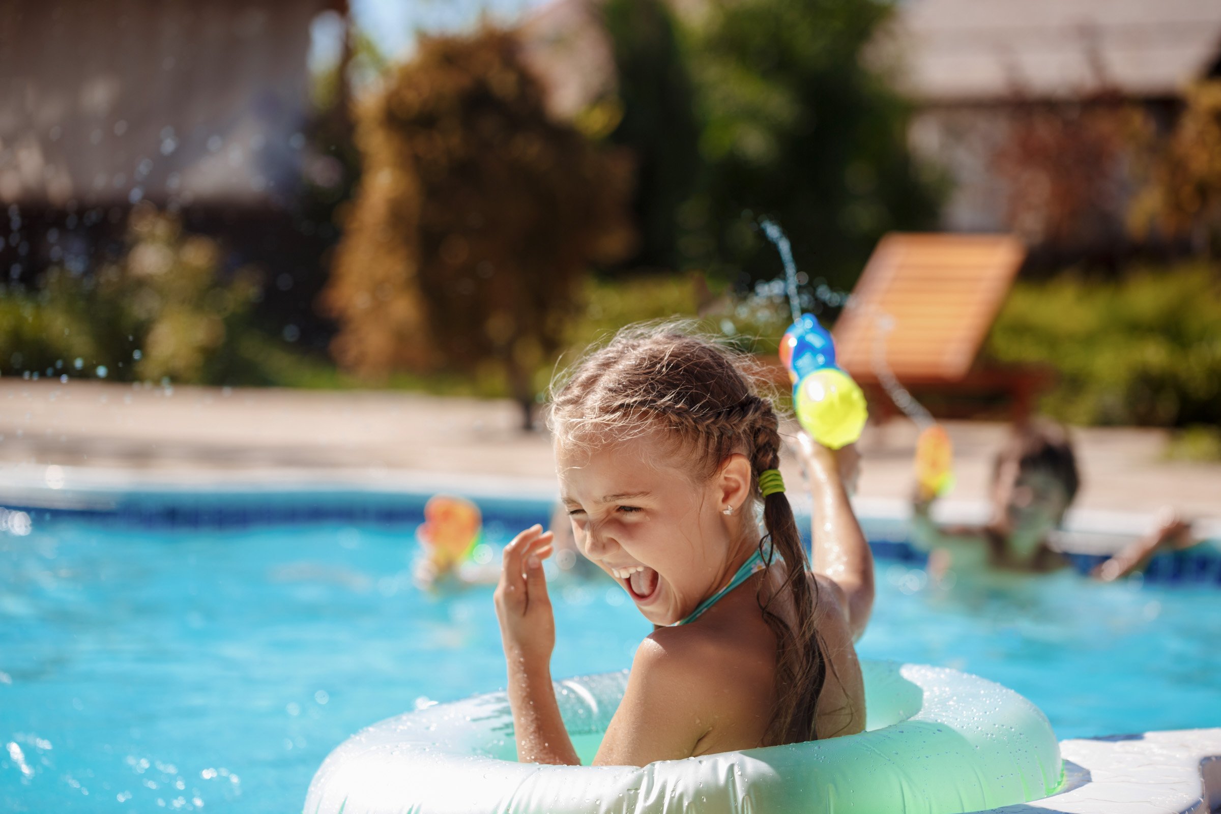 cheerful-children-playing-waterguns-rejoicing-jumping-swimming-pool_1.jpg