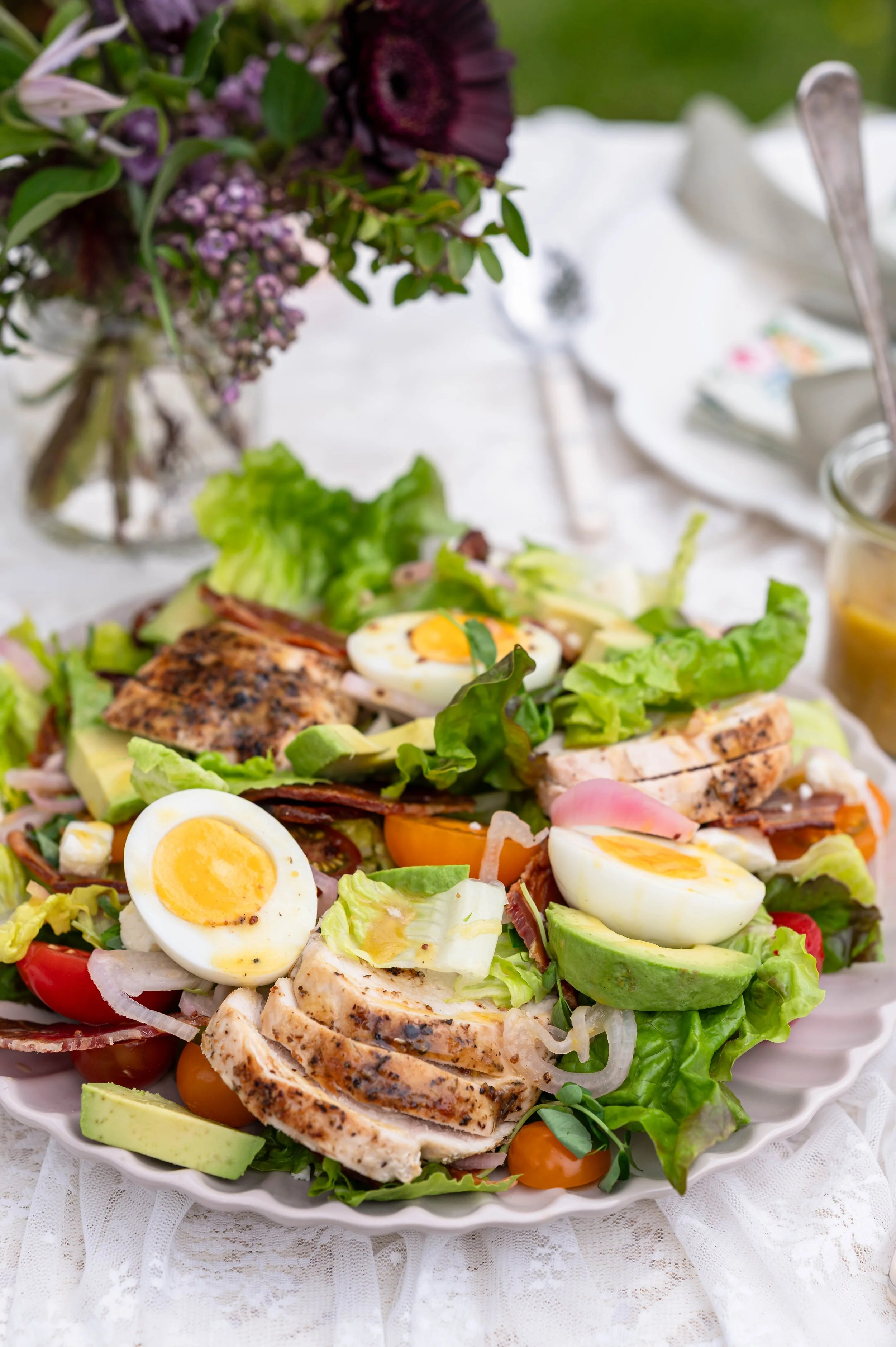 A close up of a summer cobb salad with chicken, bacon, and eggs