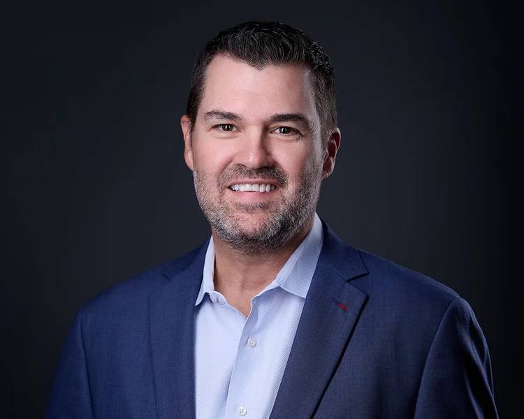 Professional headshot of a man in a navy suit at Carlos Chavez Photography studio in Tucson