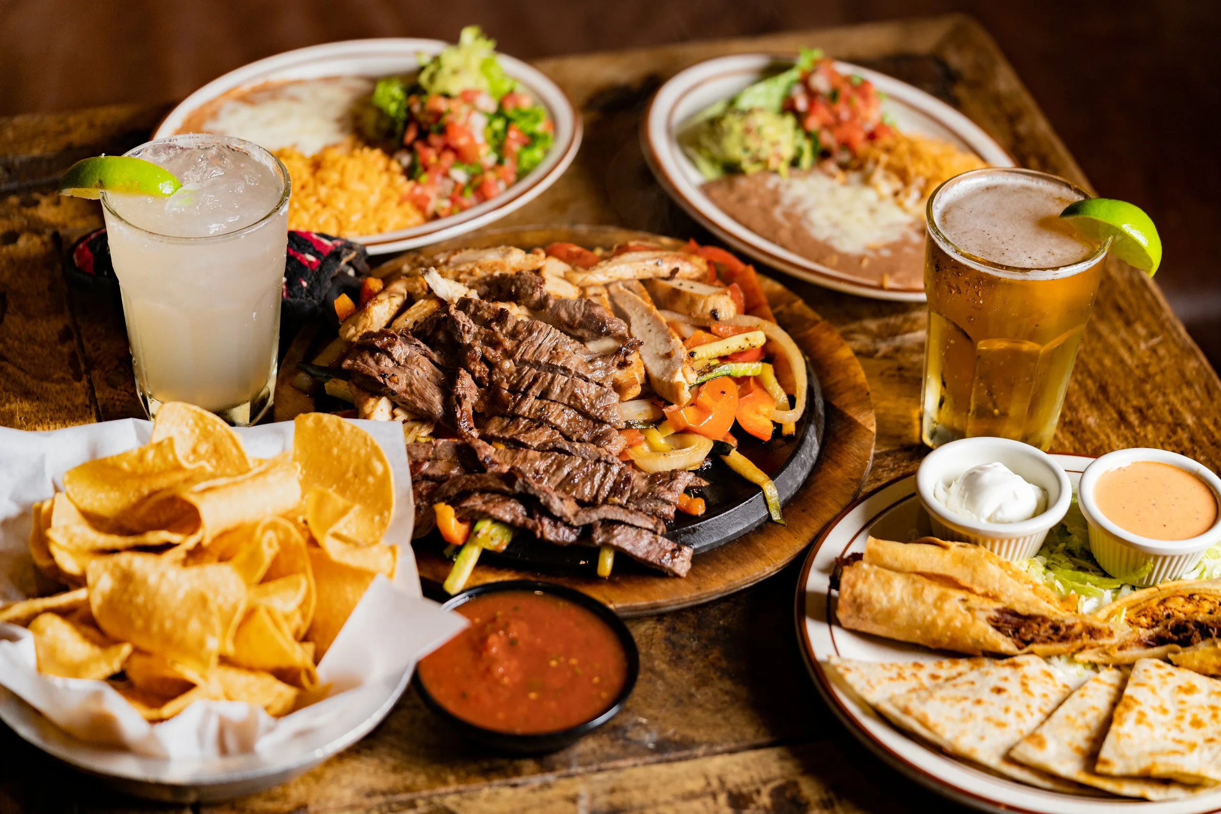 best Mexican restaurant Temecula Sizzling steak and shrimp fajitas for two served on a hot skillet with grilled bell peppers and onions, accompanied by warm tortillas, rice, beans, guacamole, and salsa.