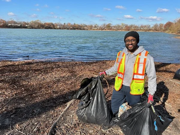 Volunteer_outside_smiling_carrying_trash_collected.jpeg