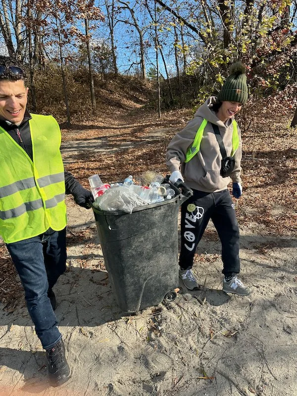 Two_volunteers_carrying_collected_trash.jpeg