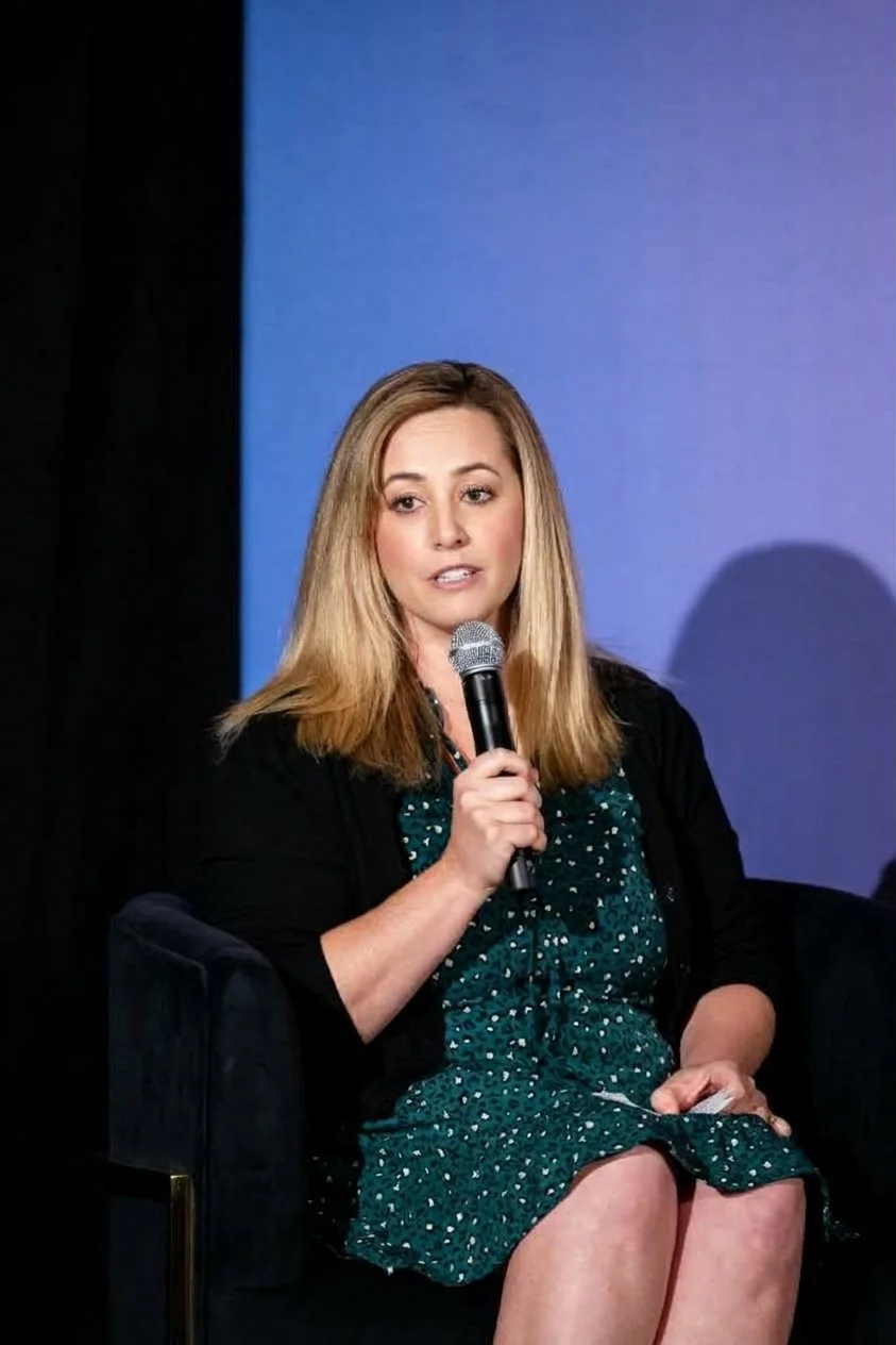 Olivia Smith speaks into a microphone while moderating an OpenAI Forum panel on how local newsrooms are using AI