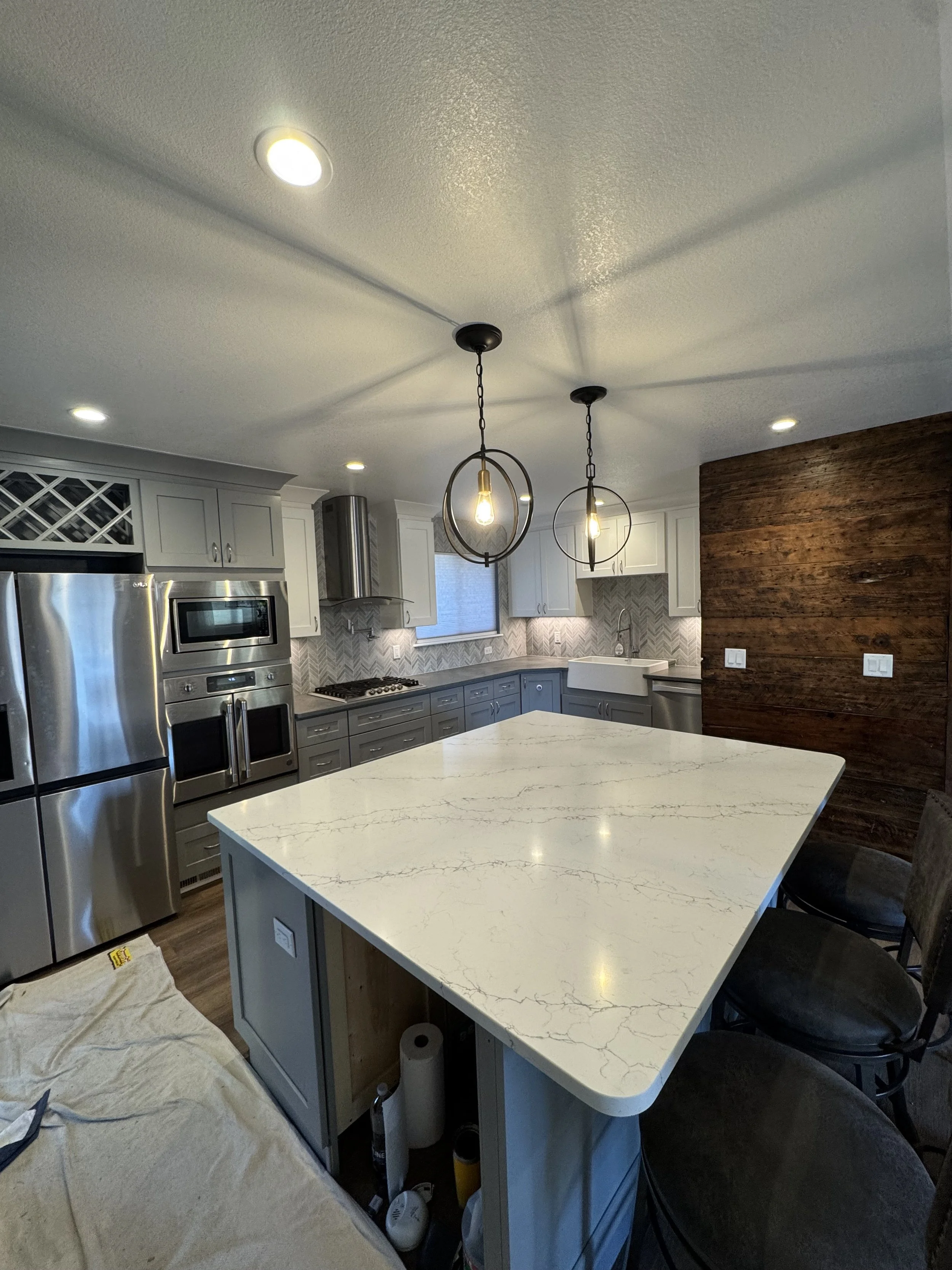 White veined island countertop with gray perimeter countertops.