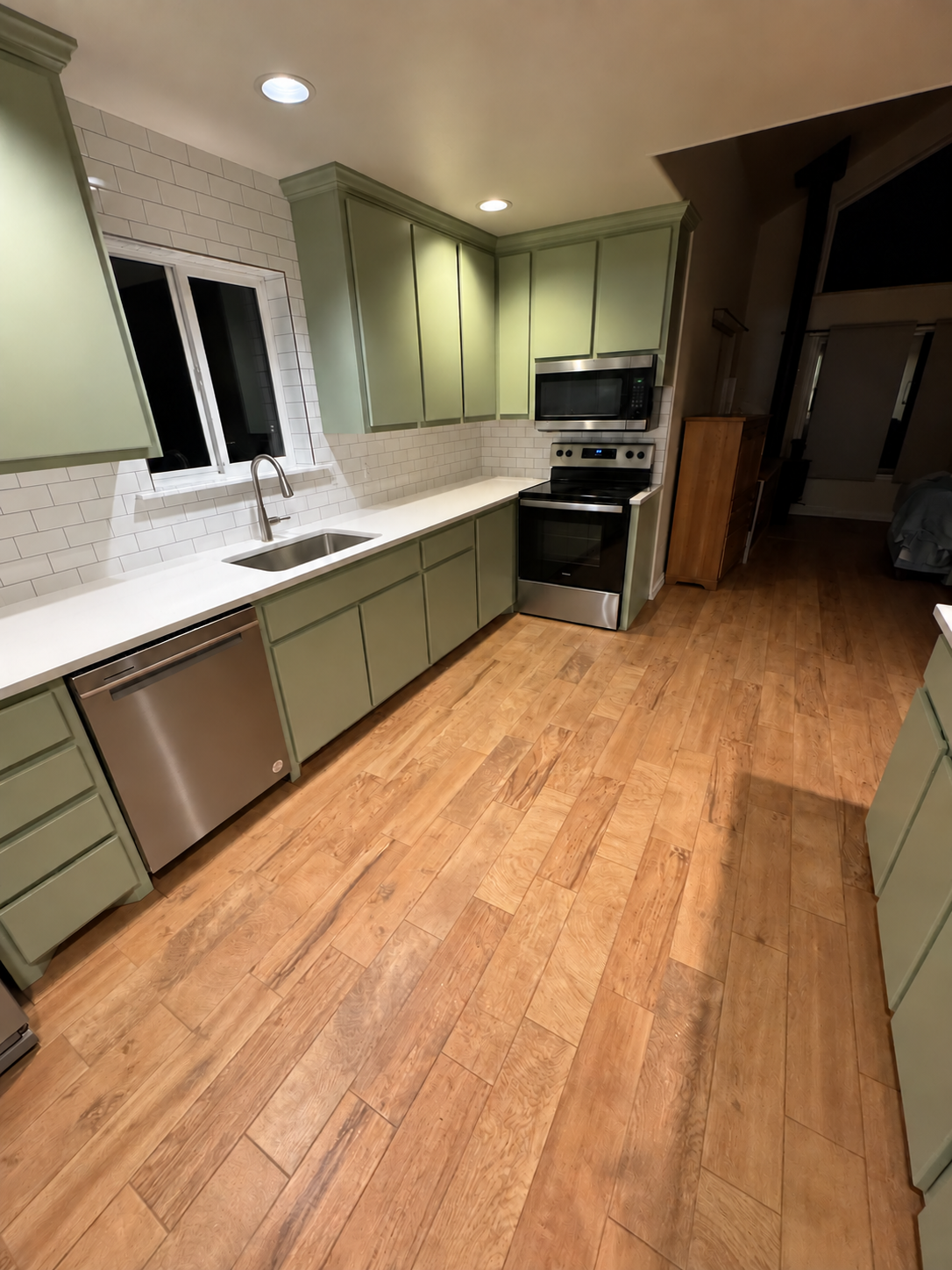 Cotton Ct kitchen countertop installation with white countertops, green cabinets and subway tile backsplash.