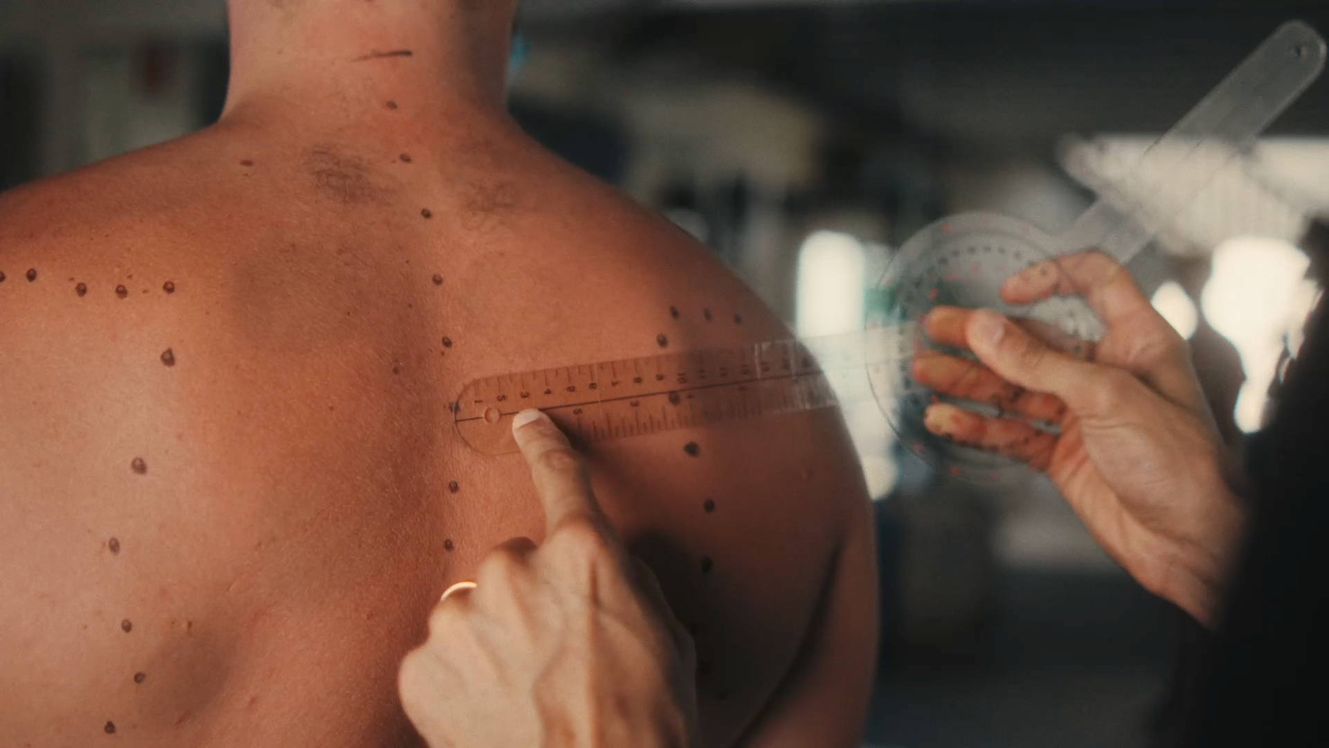 CHEK Functional Health Coach measuring scapula distance with a goniometer and spinal curvature with anatomical markings to create a custom corrective exercise & rehabilitation program delivered through a holistic methodology 