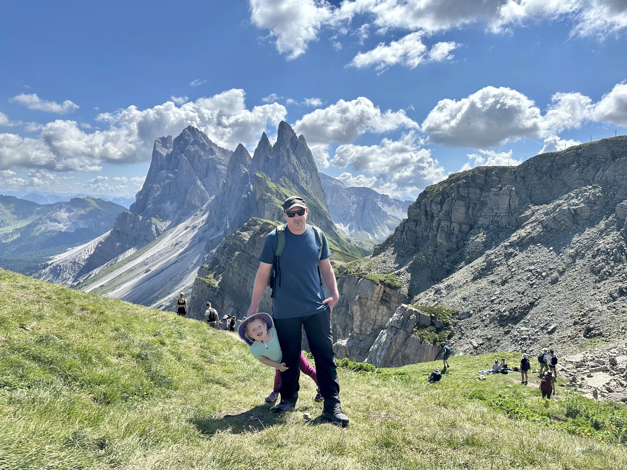 A DAD AND DAUGHTER STAND ON THE MOUNTAINS IN THE DOLOMITES IN NORTHERN ITALY. SECEDA.