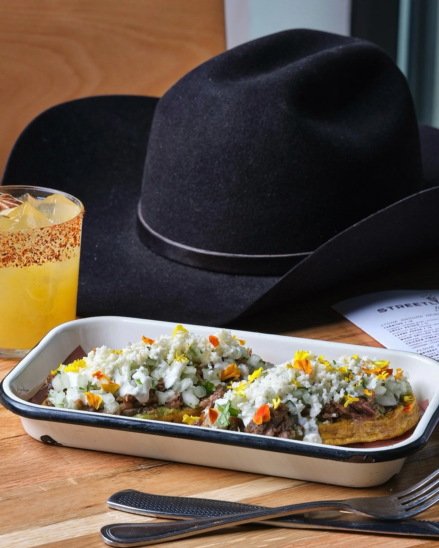 Carnitas sopes piled high with copper kettle pork, serrano-avocado salsa, queso fresco, crema, cilantro &amp; onion. Now served every day of the week, including Mondays!