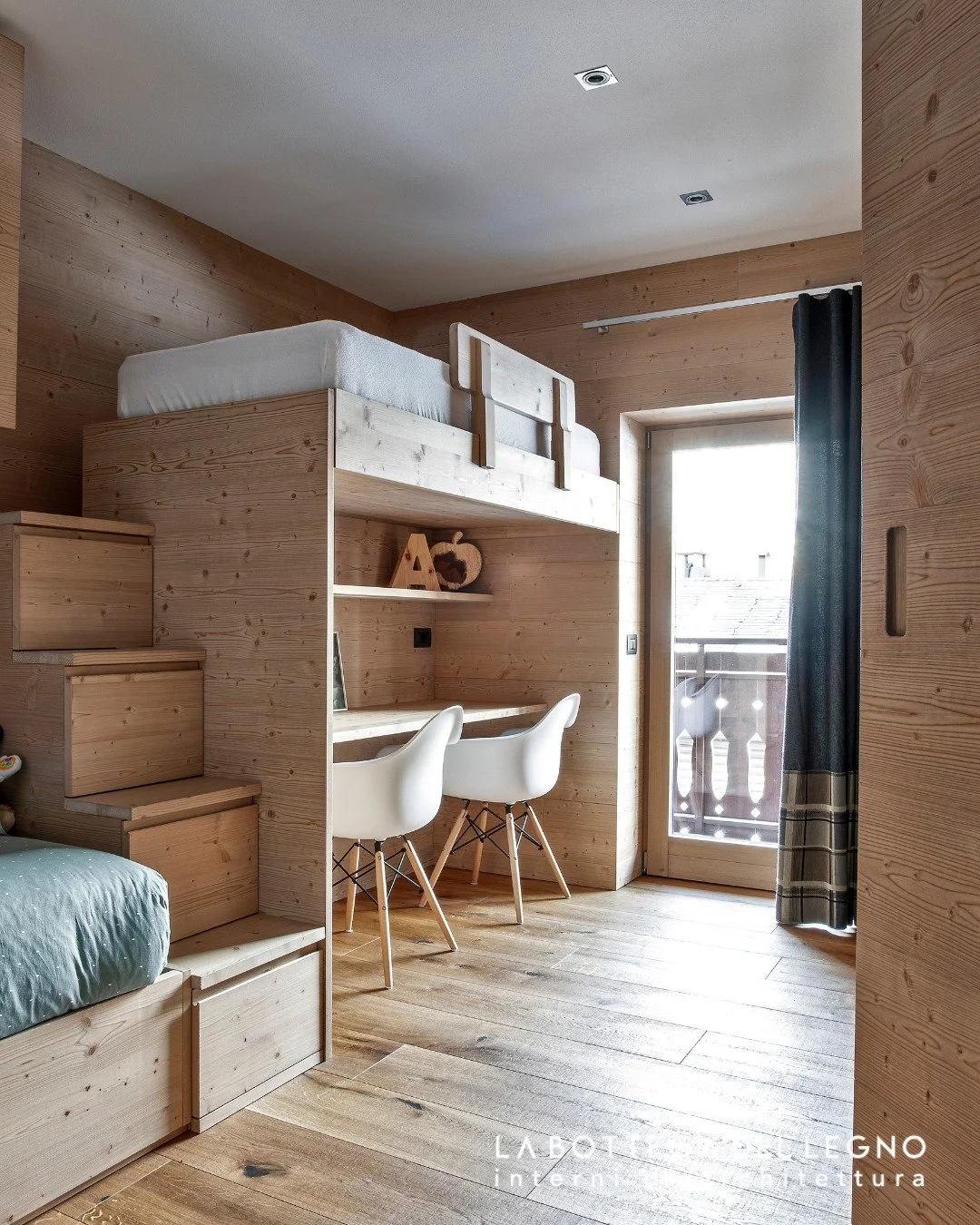 .
𝑰𝒍 𝒑𝒊𝒄𝒄𝒐𝒍𝒐 𝒎𝒐𝒏𝒅𝒐 𝒔𝒖 𝒎𝒊𝒔𝒖𝒓𝒂

Una cameretta in abete con due letti pensati per accogliere riposo e fantasia. 
La scaletta sale leggera verso il letto a castello, mentre sotto, la scrivania diventa rifugio per lo studio, il diseg