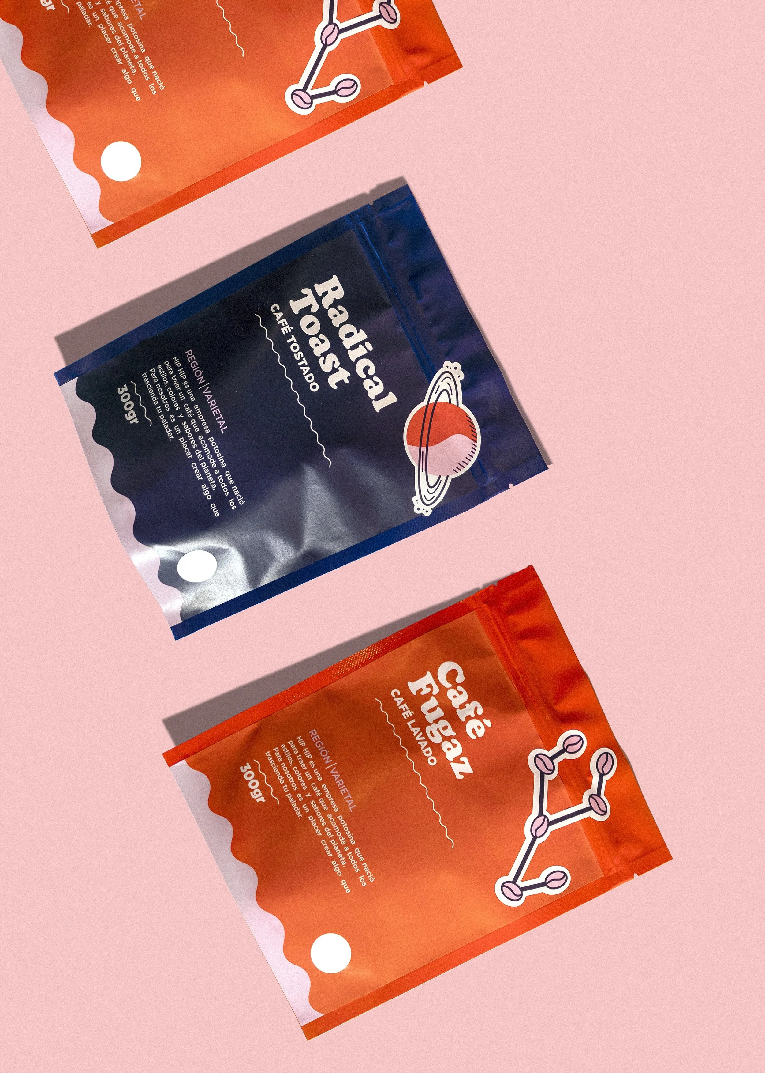 Three colorful coffee bags with space-themed designs on a pink background.
