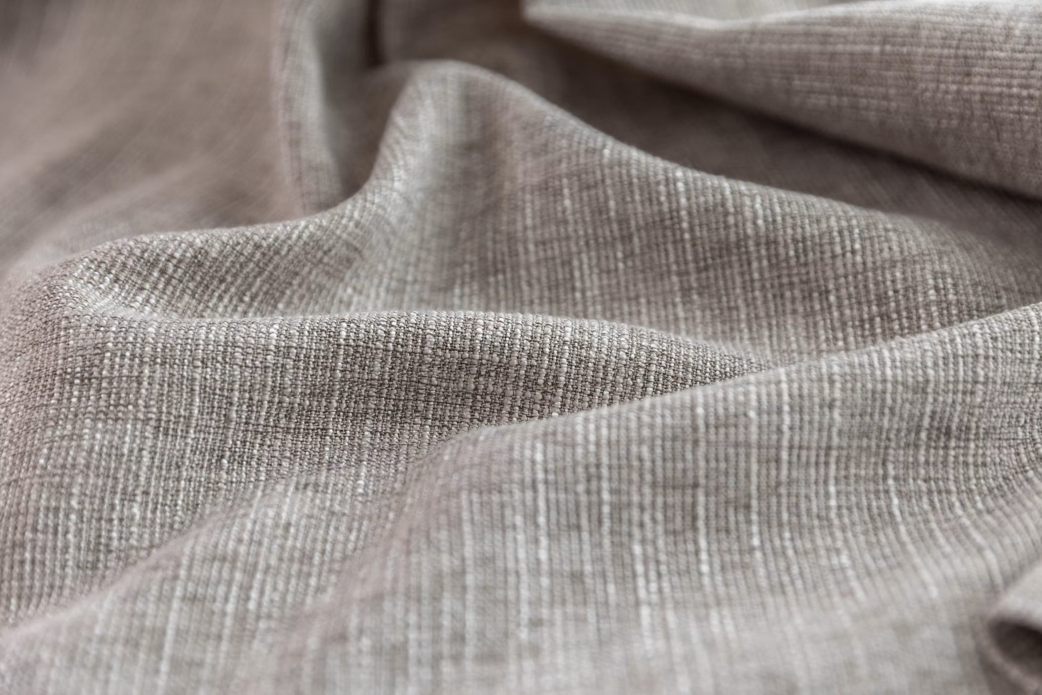 Close-up of pale grey fabric arranged in soft vertical folds