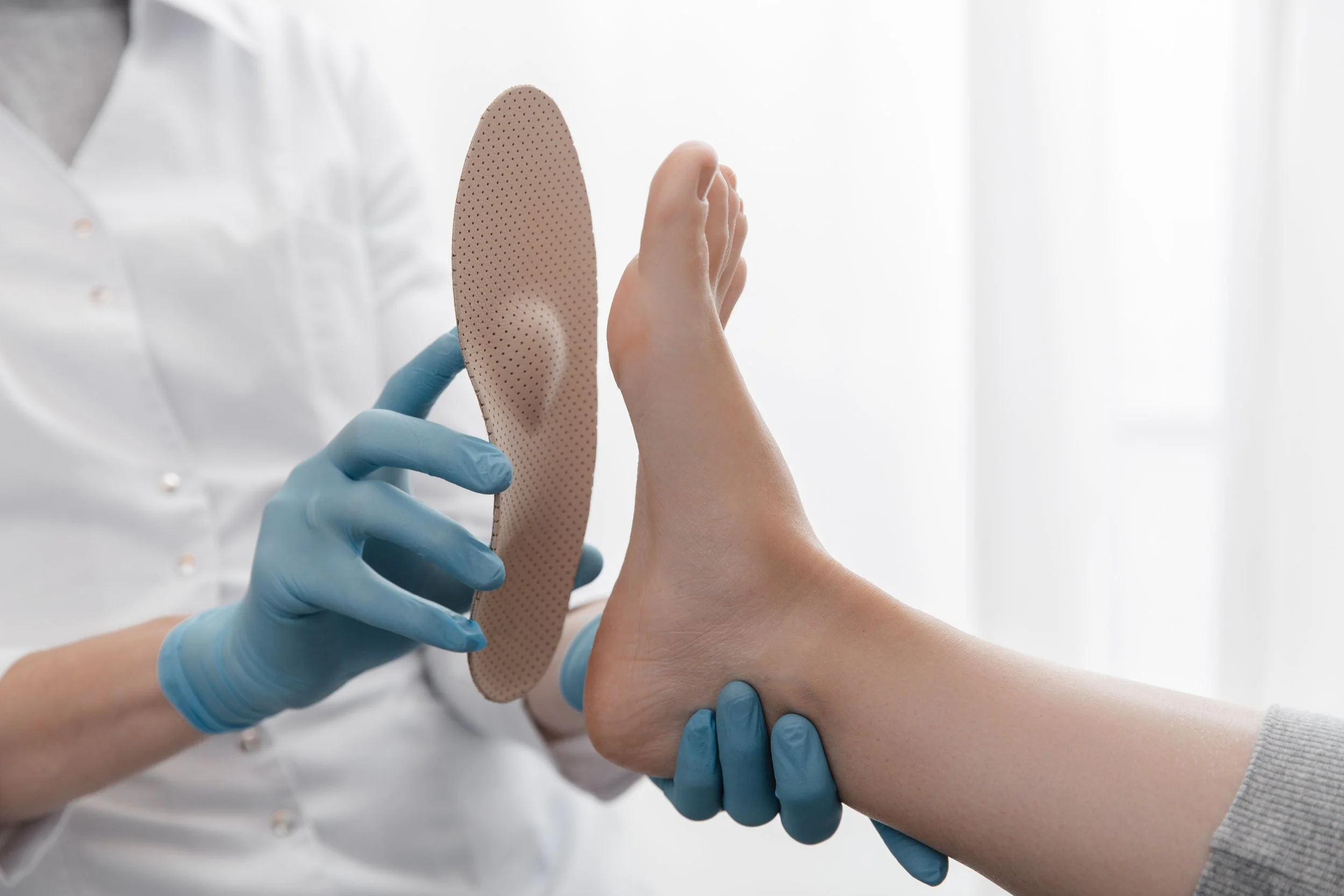 Podiatrist fitting orthopedic insole to patient