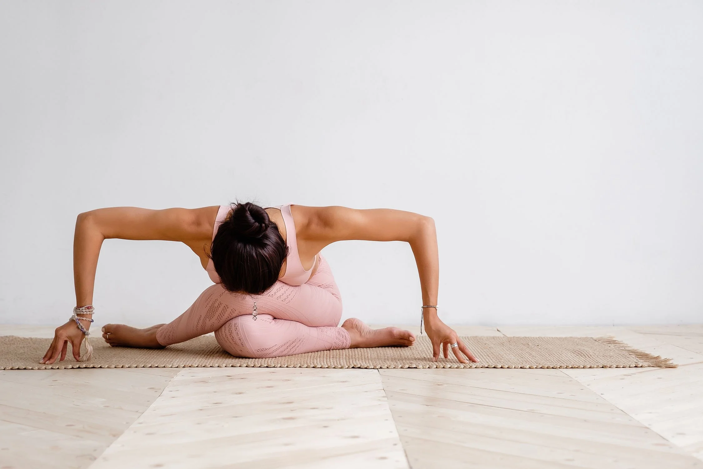Woman folding forward toward the earth in a seated yoga pose.