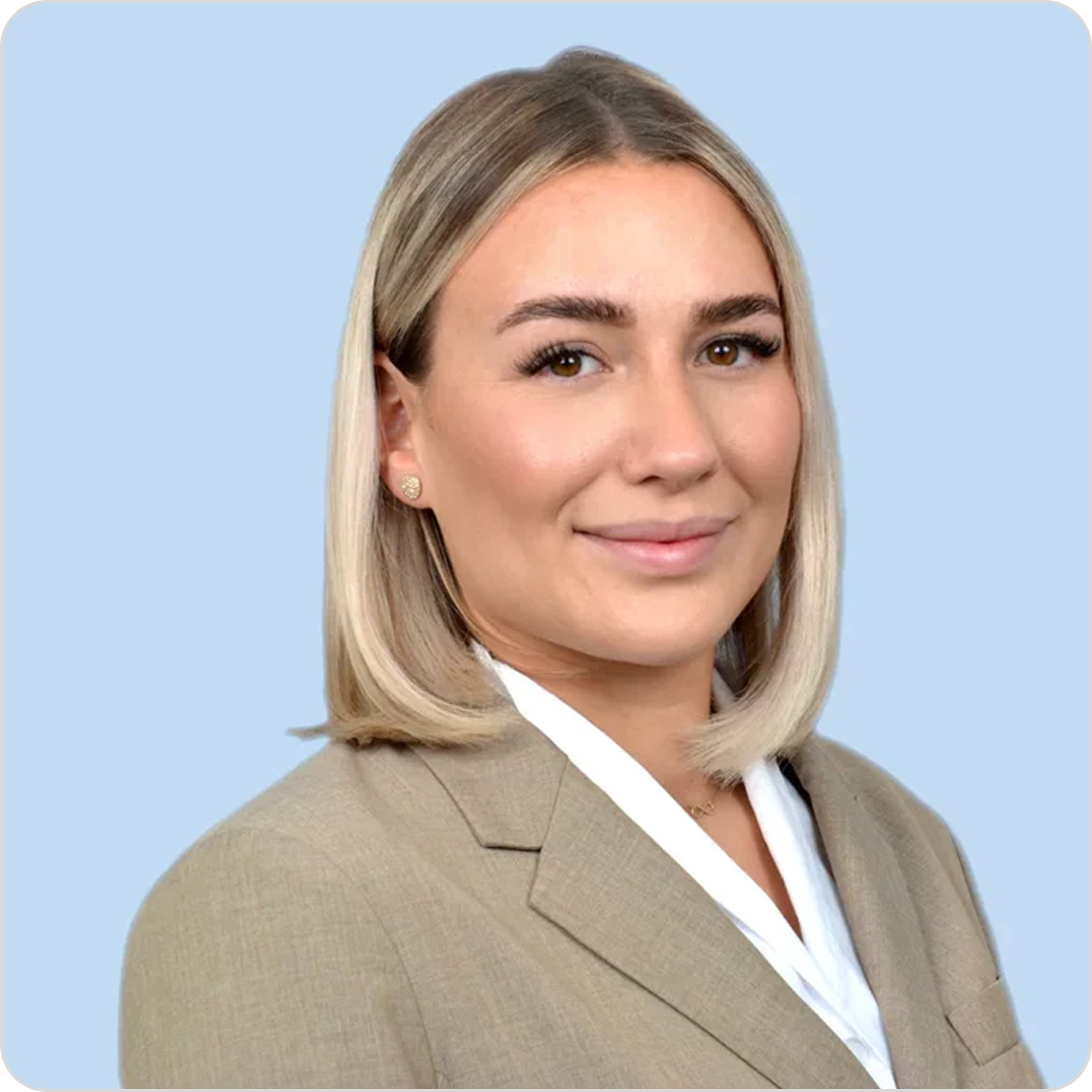 Ein professionelles Porträt einer Frau in einem beige Business-Anzug mit gelockerten blonden, schulterlangen Haaren vor einem hellblauen Hintergrund.