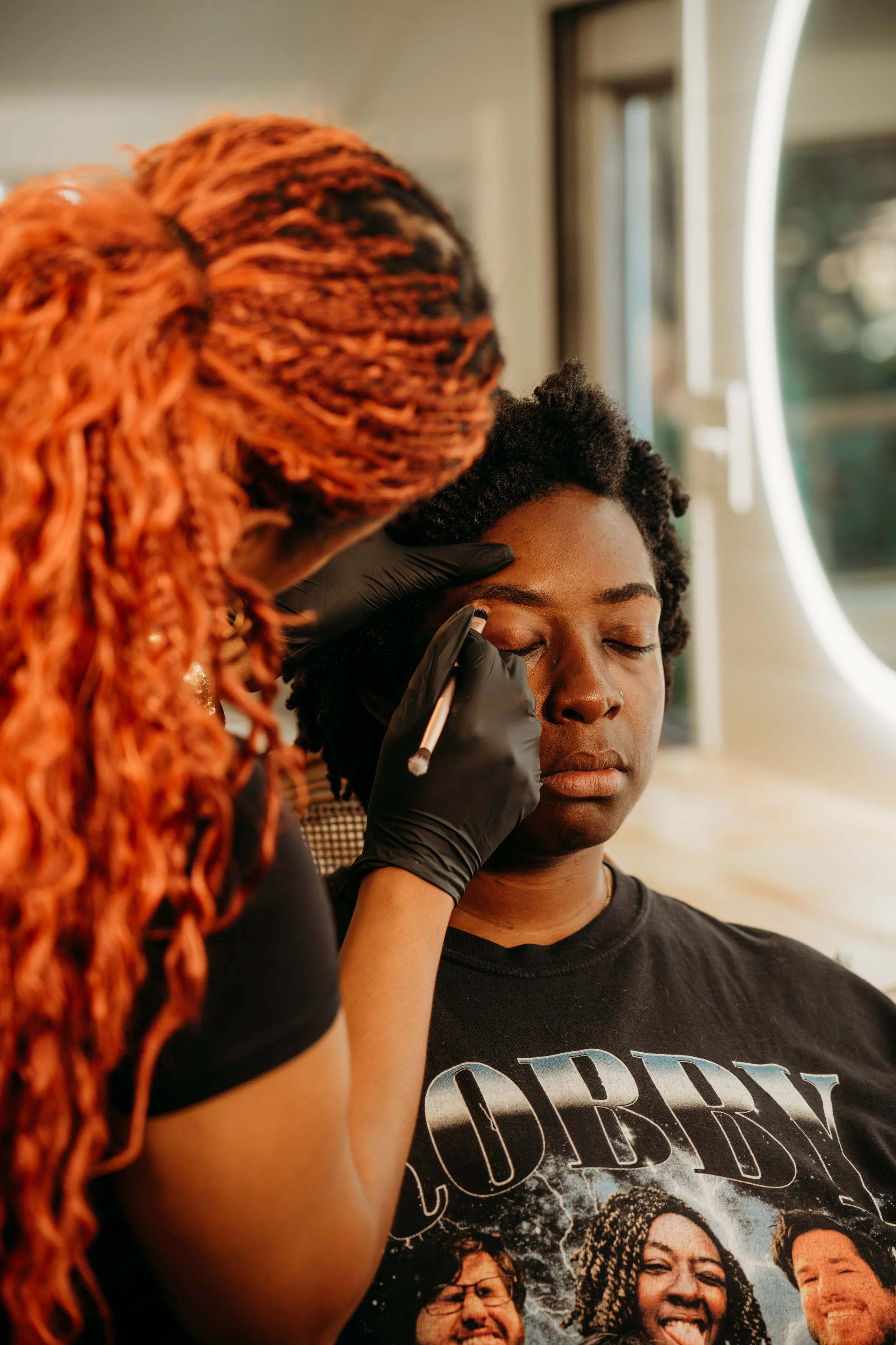 Kenya Beats Makeup Artistry applying soft glam makeup to a bride with dark skin in Raleigh, NC.