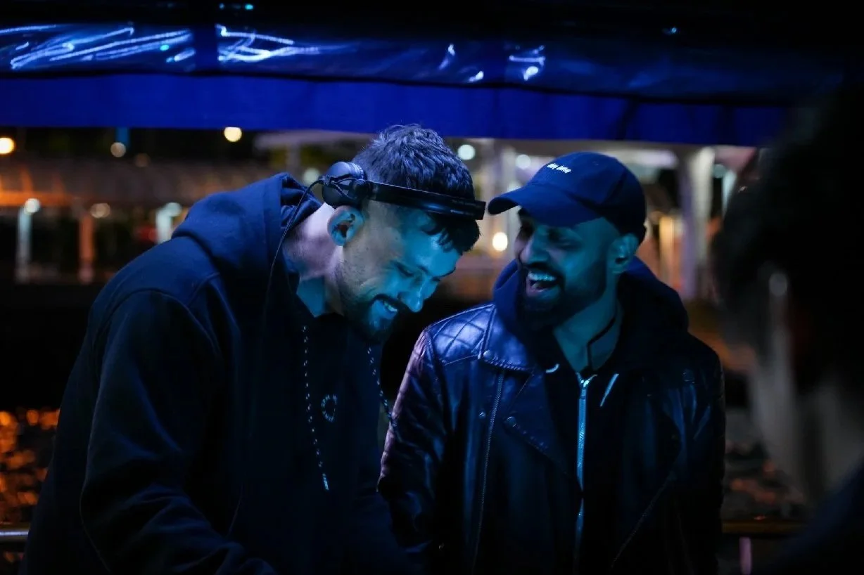 DJs Ignotus and Immuno.HK performing a live back-to-back set under blue lights during a night-time junk boat party in Hong Kong