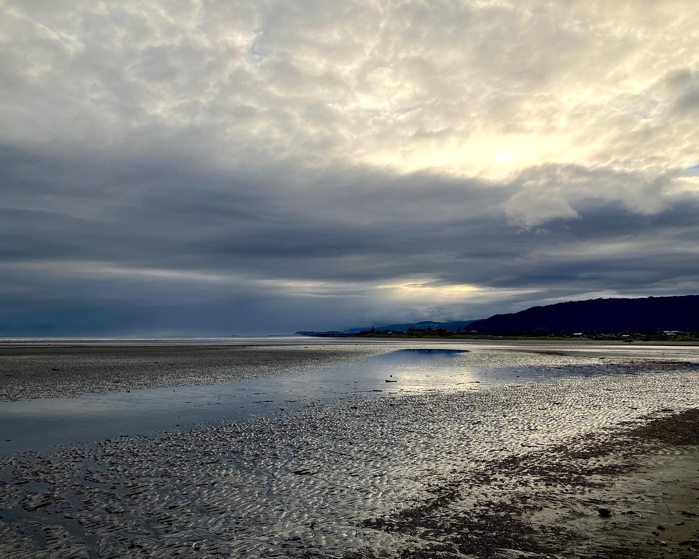 A very still morning on Paraparaumu beach which was swept clean by recent storms, still evident in the brooding purple skies. Shafts of light through the cloud lit up the pocked seashore. 

 https://linktr.ee/DeeWarringArt

#photography #beachphotogr