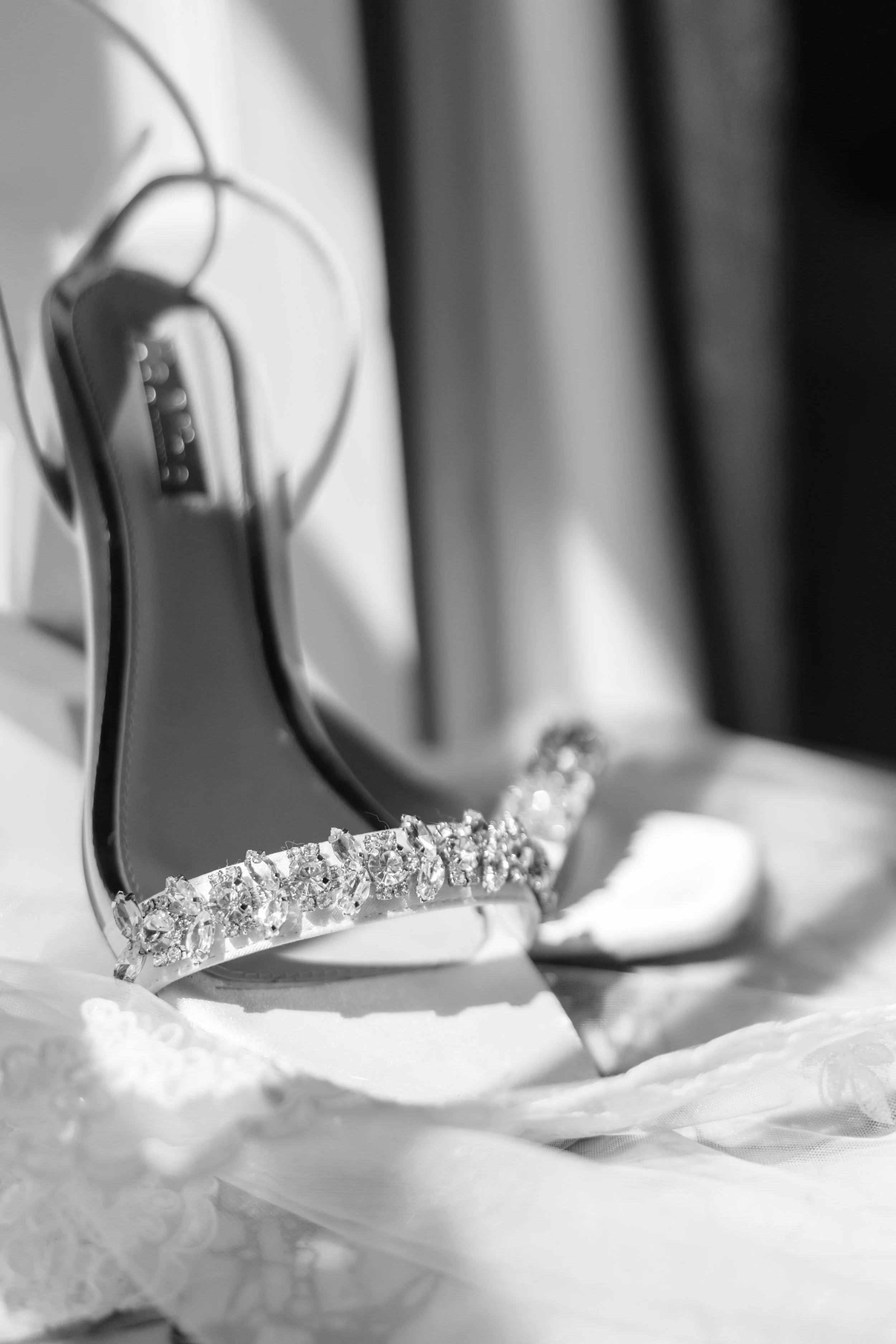 Bridal shoes are arranged artfully on a side table in the sunlight