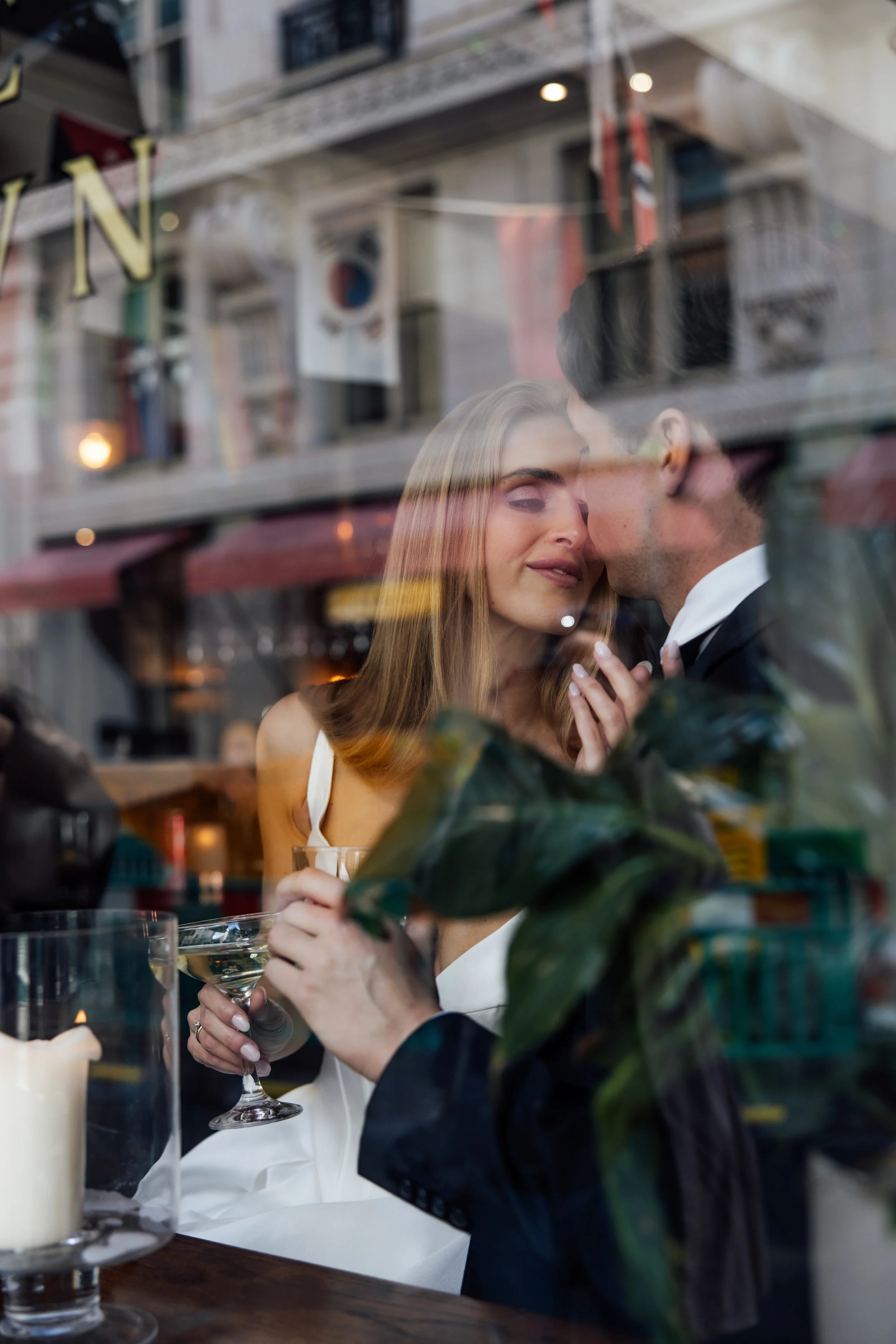 Just married couple sit together in a London pub cheersing drinks