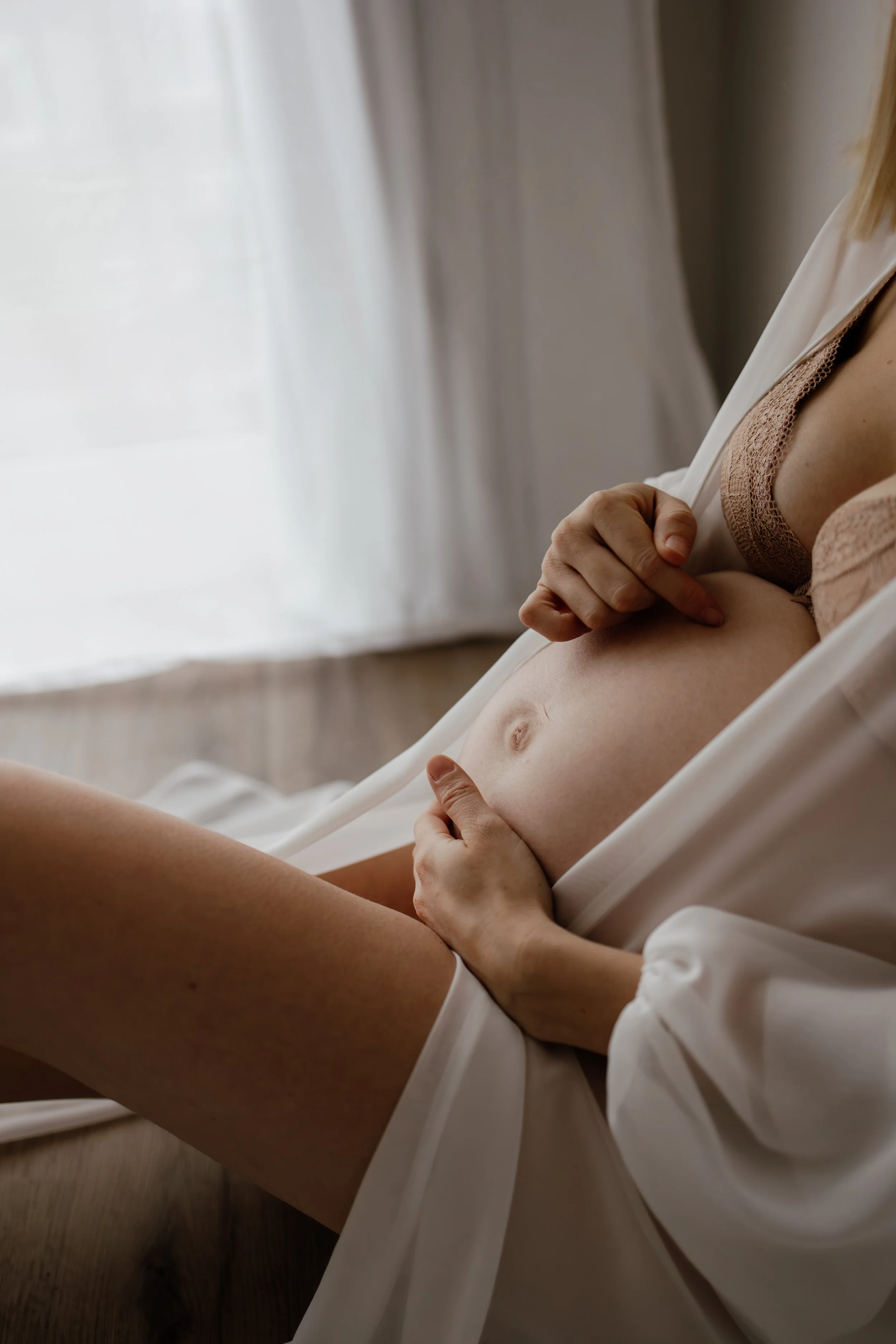 Pregnant mum wearing a sheer robe and holding her bump