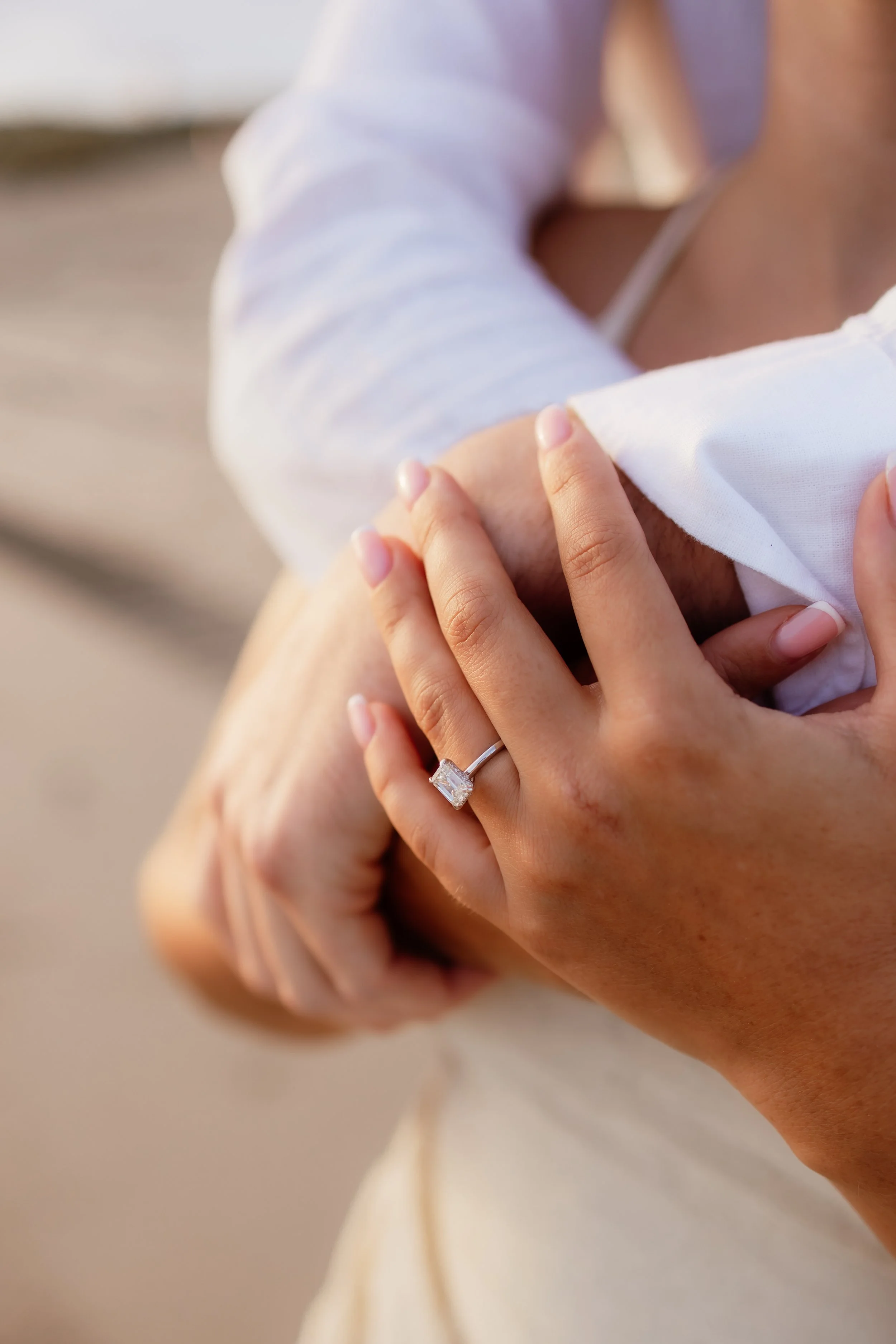 Closeup of the hands of a newly engaged couple showing engagement ring