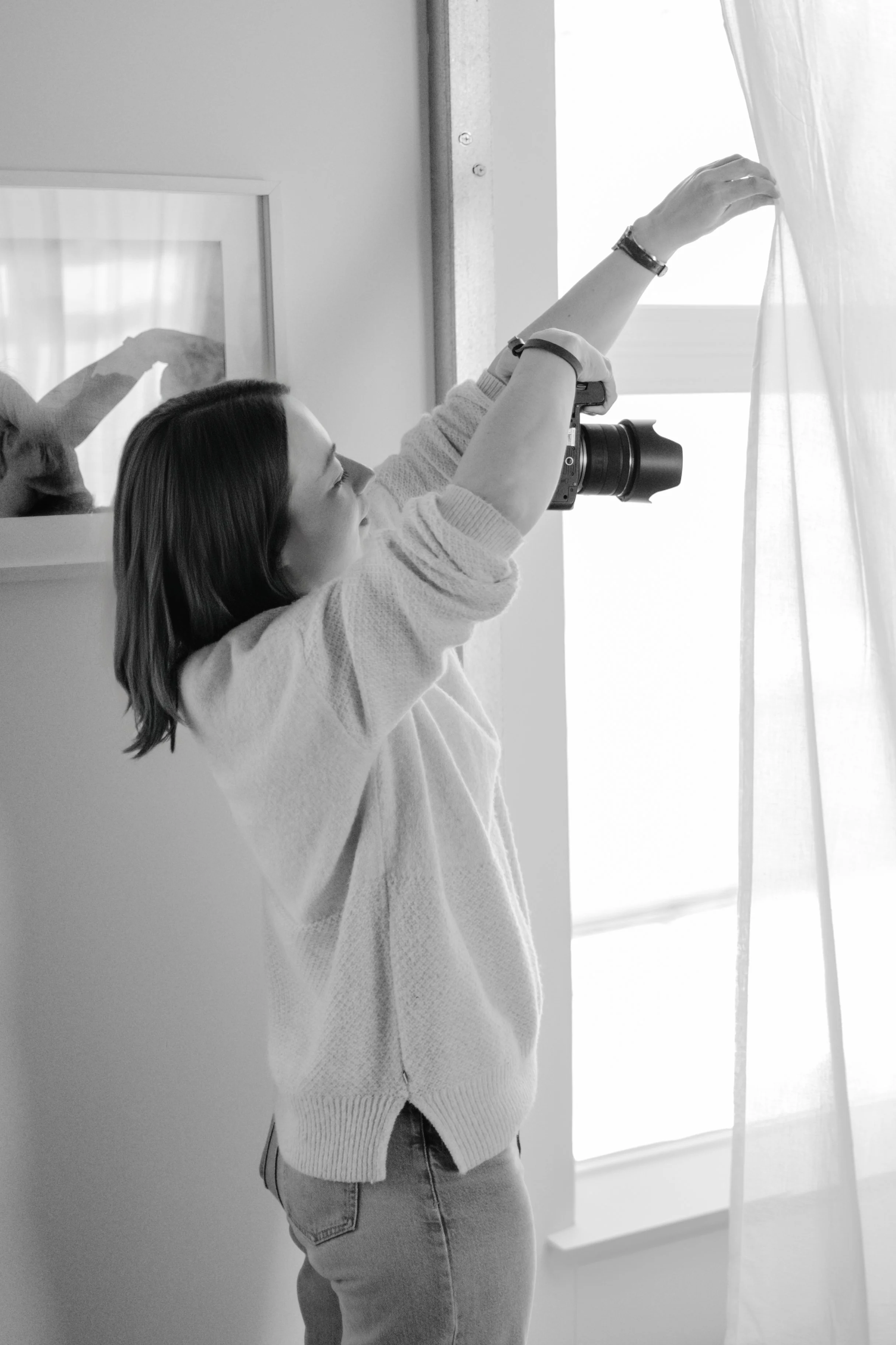 Liv Moore Photography working at a maternity session, holding a sheer curtain partially in front of her camera