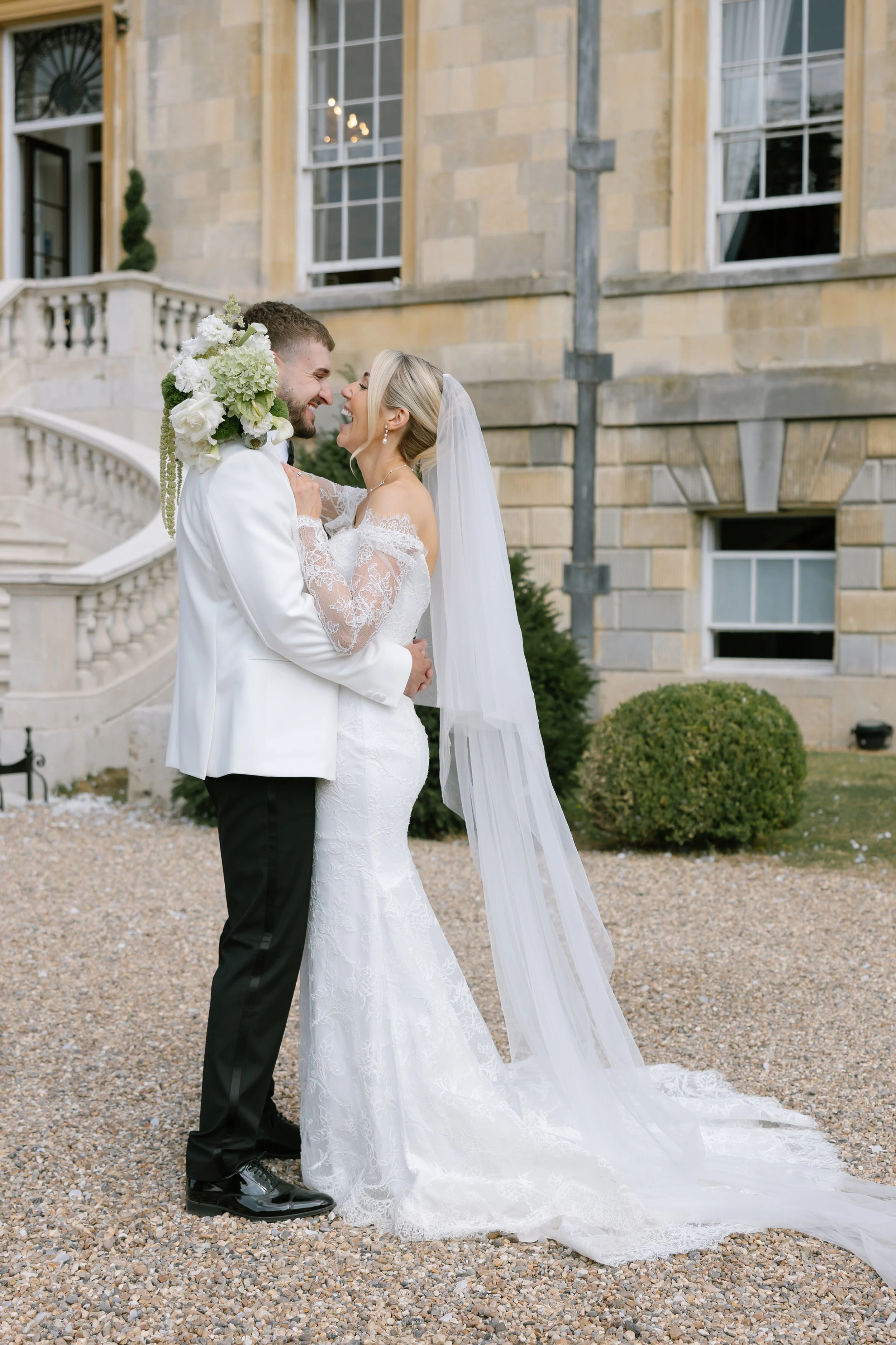 Newlywed couple laugh together outside Botley's Mansion in Hampshire