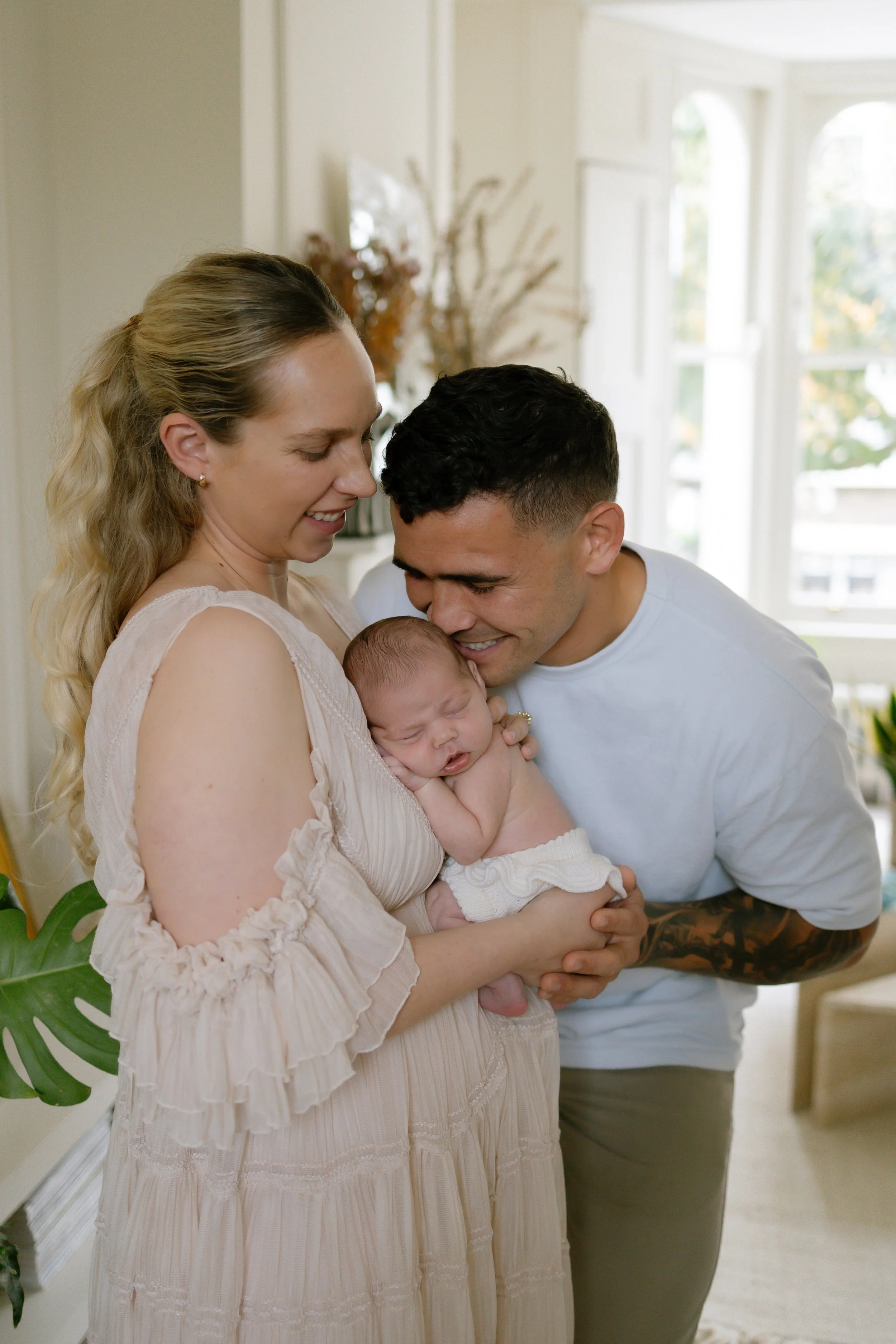 New parents cuddle baby at home