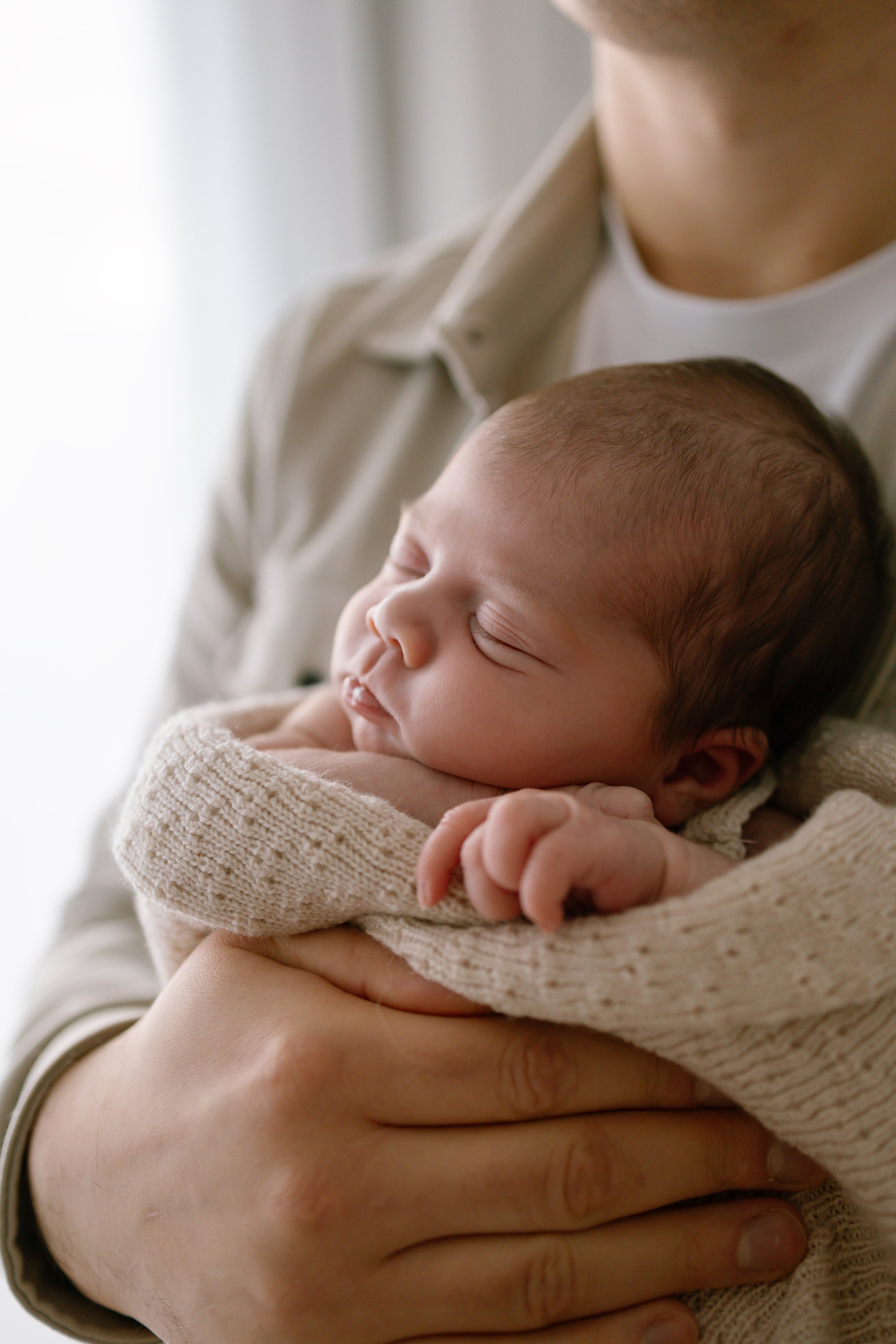 New dad holds his baby daughter while she sleeps