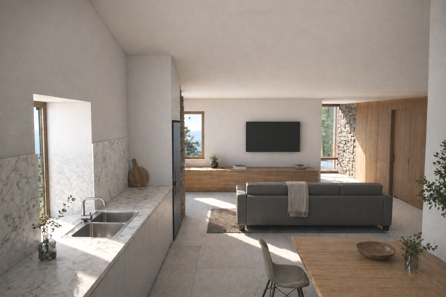 Vista interior de vivienda en Oia (Galicia) tras su rehabilitación integral, con integración de cocina y salón en un espacio continuo, optimizando iluminación natural y eficiencia energética en un contexto rural.