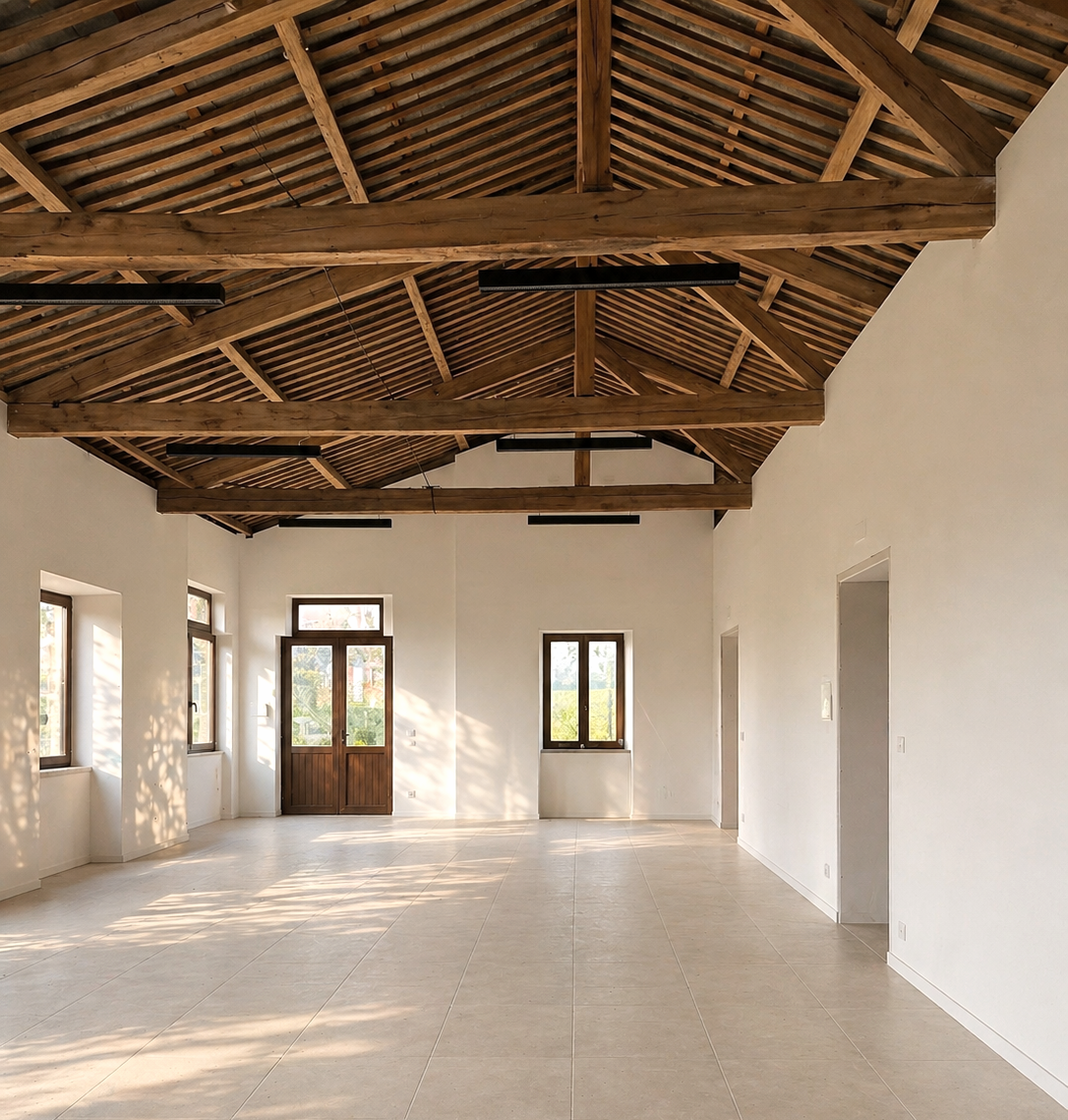 Interior rehabilitado de la Escuela Unitaria de San Lorenzo en A Guarda (Pontevedra), con estructura de madera vista y espacio diáfano iluminado, ejemplo de arquitectura en madera y rehabilitación.