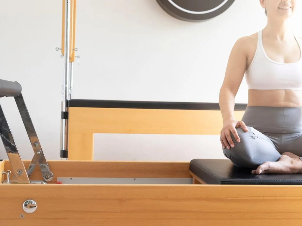 Woman sitting on a reformer