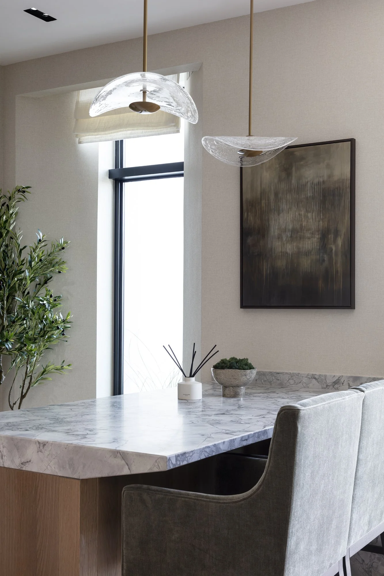hand blown clear bubble pendant lights over a kitchen island for Nineteen Interiors