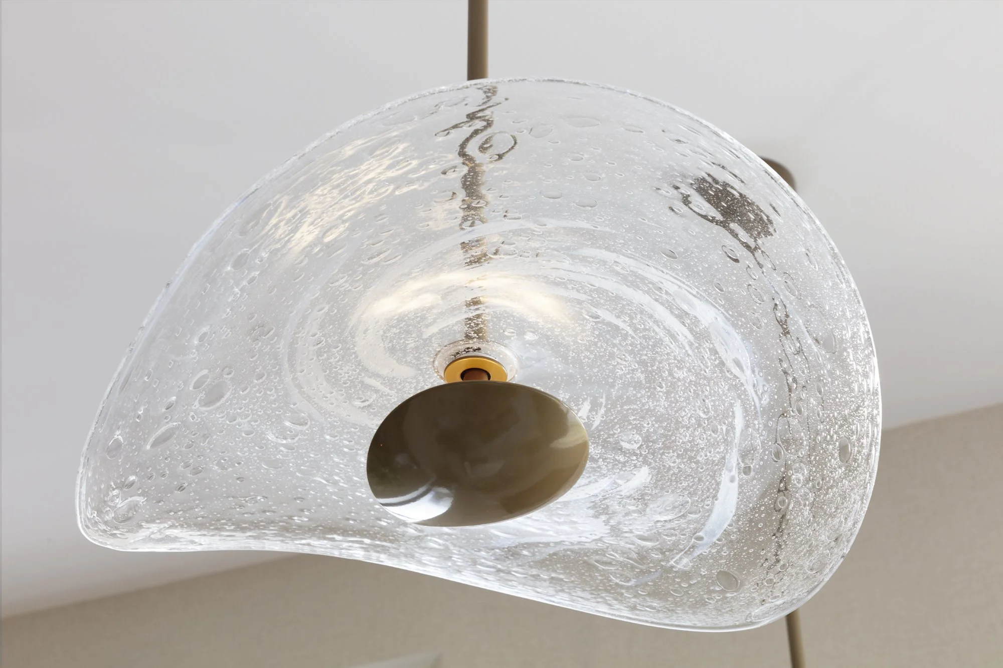 hand blown clear bubble pendant lights over a kitchen island for Nineteen Interiors