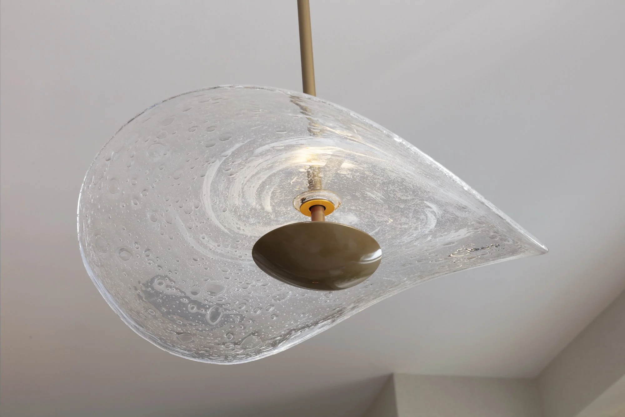 hand blown clear bubble pendant lights over a kitchen island for Nineteen Interiors