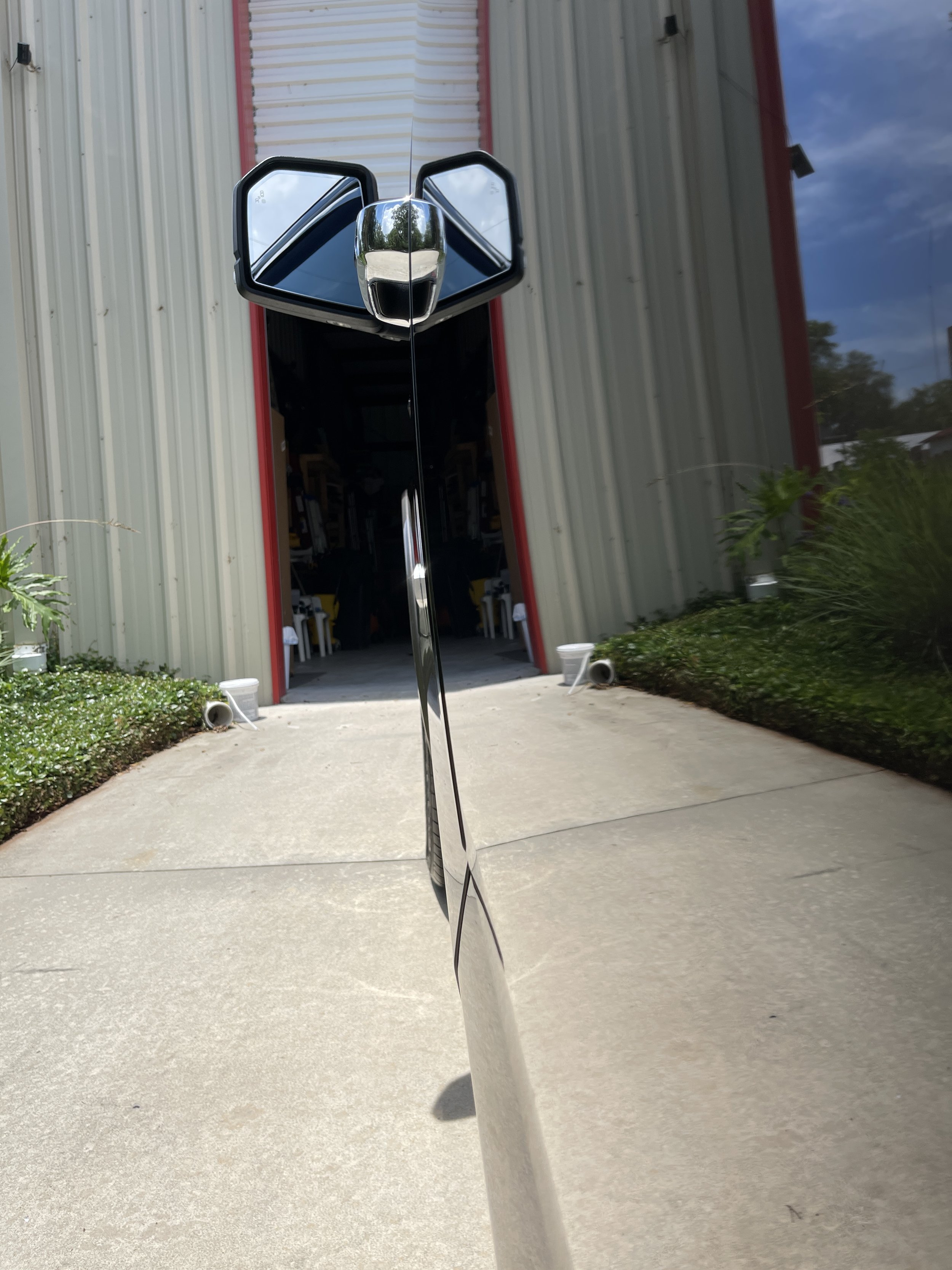 Black truck mirror reflecting a freshly detailed truck after professional polishing and paint protection.