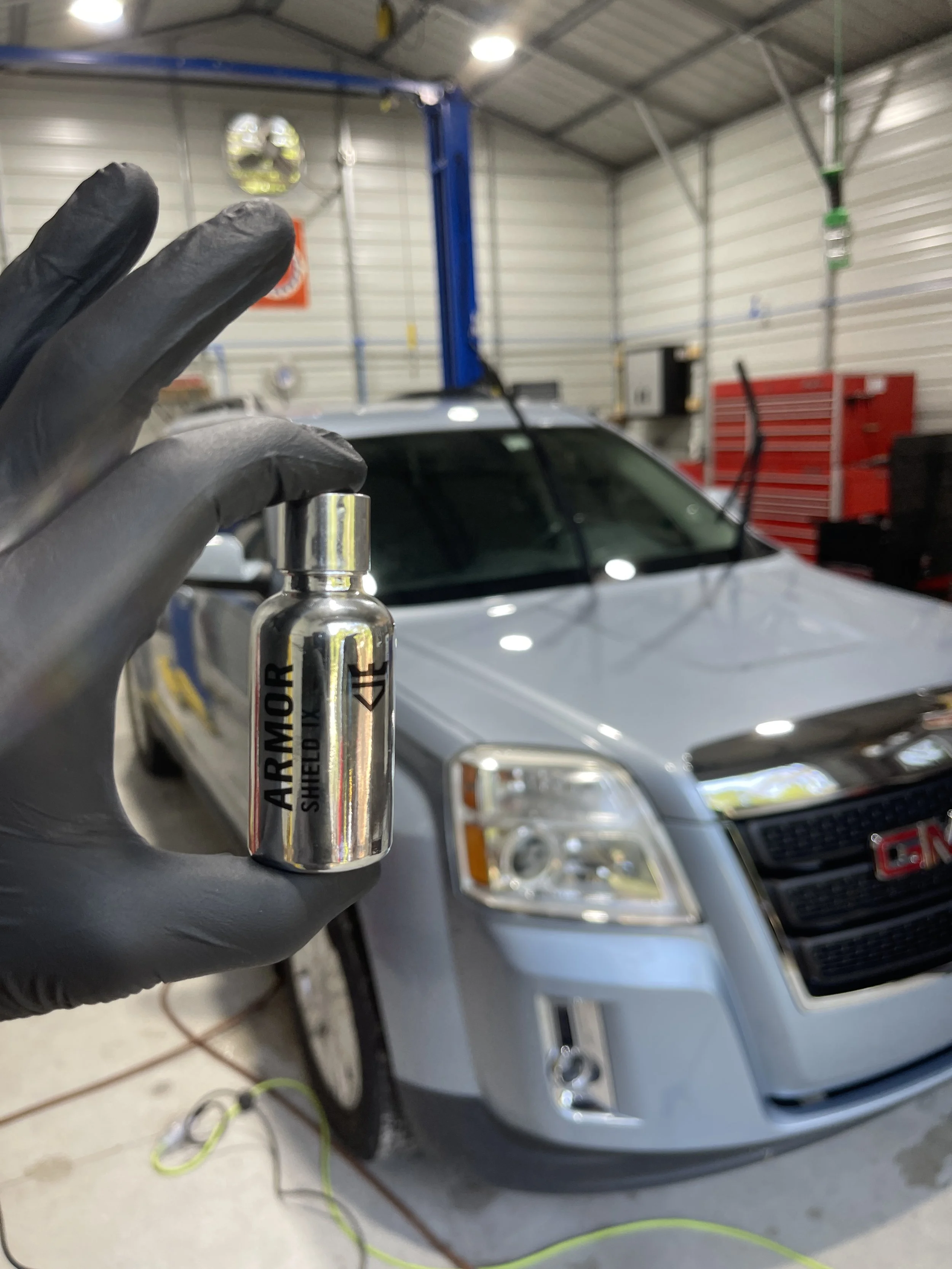 A ceramic coating being applied to a blue suv