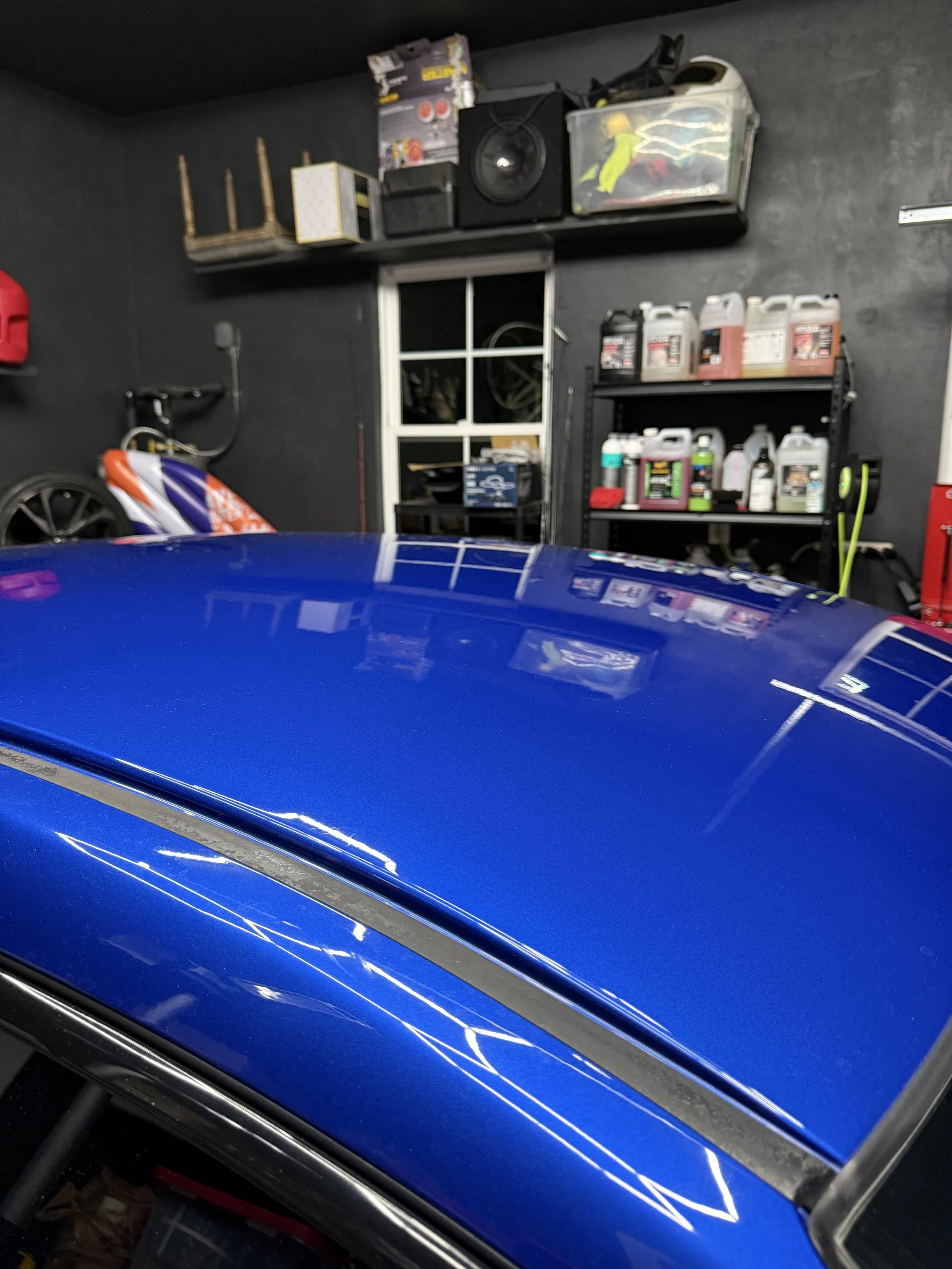 Close-up of a blue sports car after professional polishing and water spot removal.