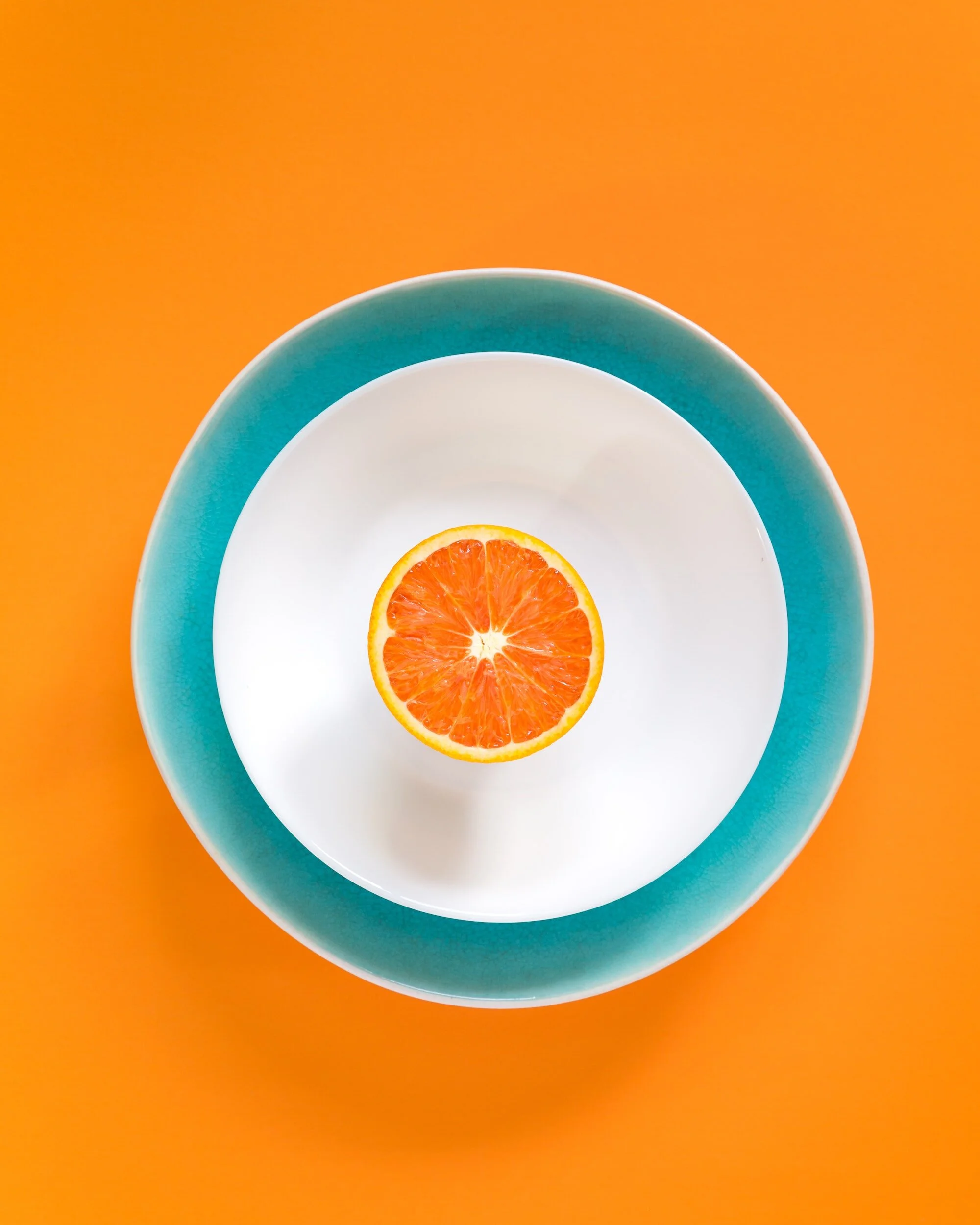 Complementary blue bowl and orange with an orange background